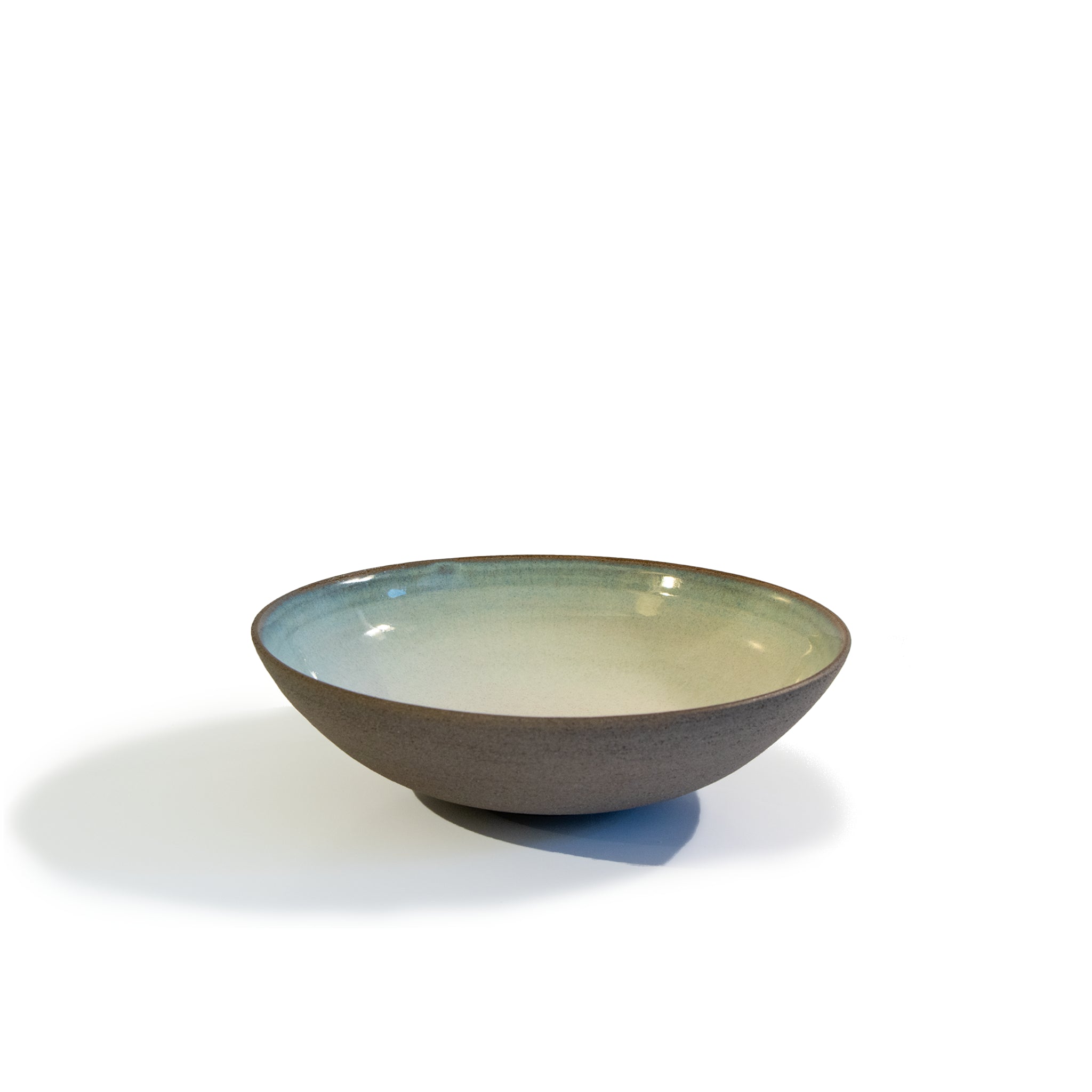 Het AB Ceramics Diep Bord Grijs Opaal D21 van AB Ceramics is een handgedraaid diep bord met matte grijze buitenkant en glanzend opaalblauwe binnenkant, gefotografeerd op een witte ondergrond met zachte schaduw aan de linkerkant.