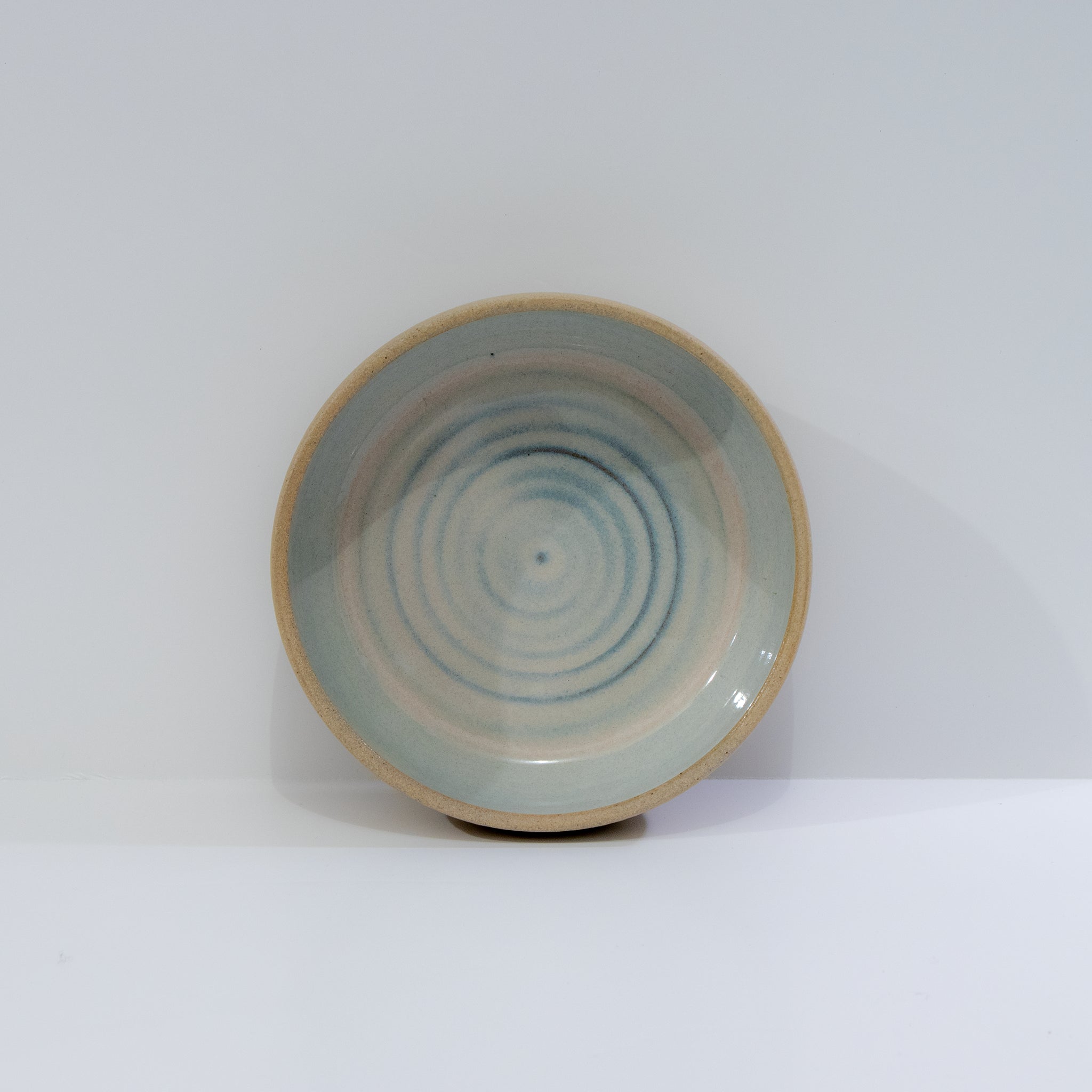 De AB Ceramics Schaal Spiraal Geel Opaal D13,5 is een handgemaakte keramische schaal met spiraalpatroon in geel opaaltint, eenvoudig en rustiek van uitstraling, en voorzien van een licht opstaande rand.