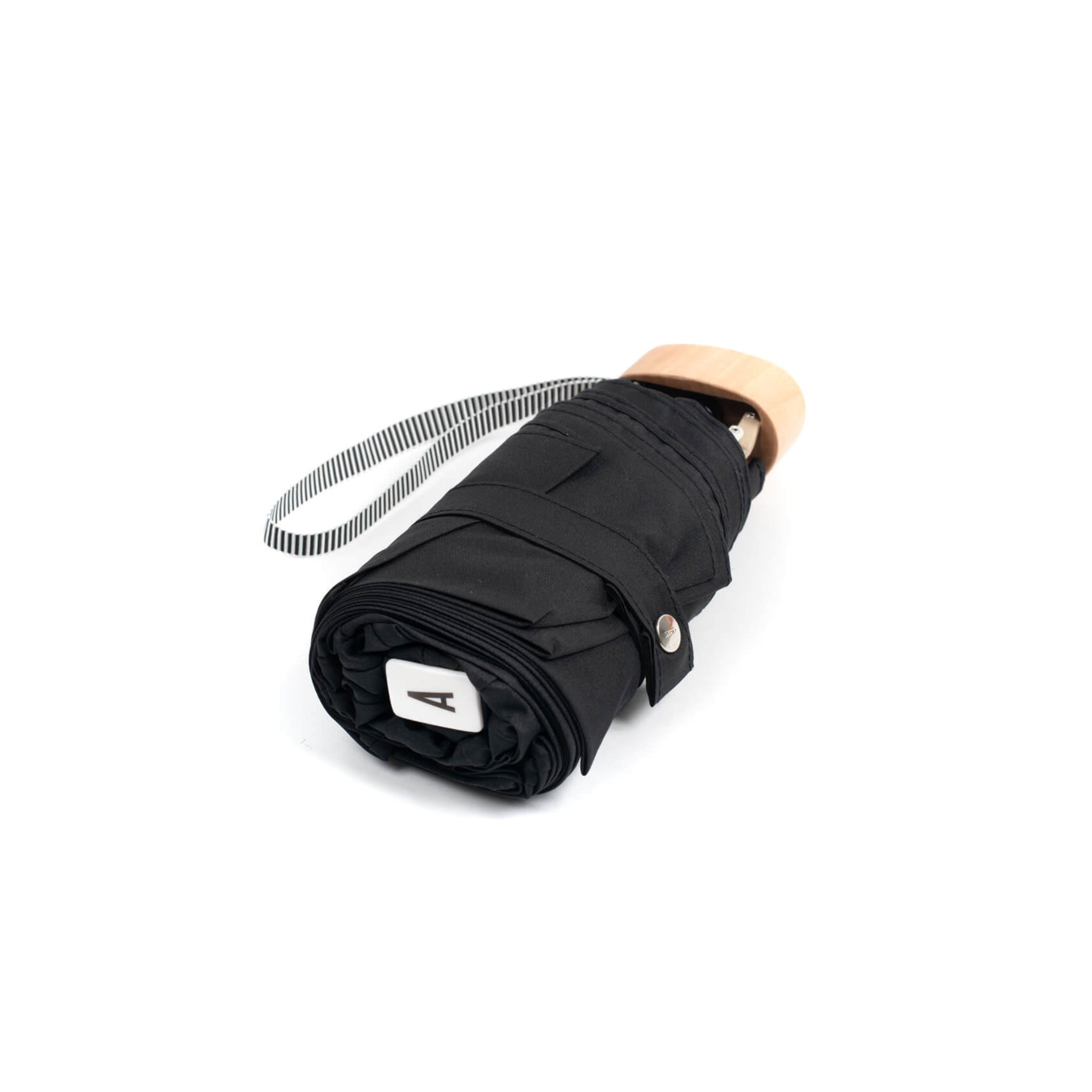 De Anatole Micro Paraplu Jane Zwart van Anatole is een gesloten zwarte paraplu met een houten handvat en een zwart-wit gestreepte polsband, afgebeeld tegen een witte achtergrond.