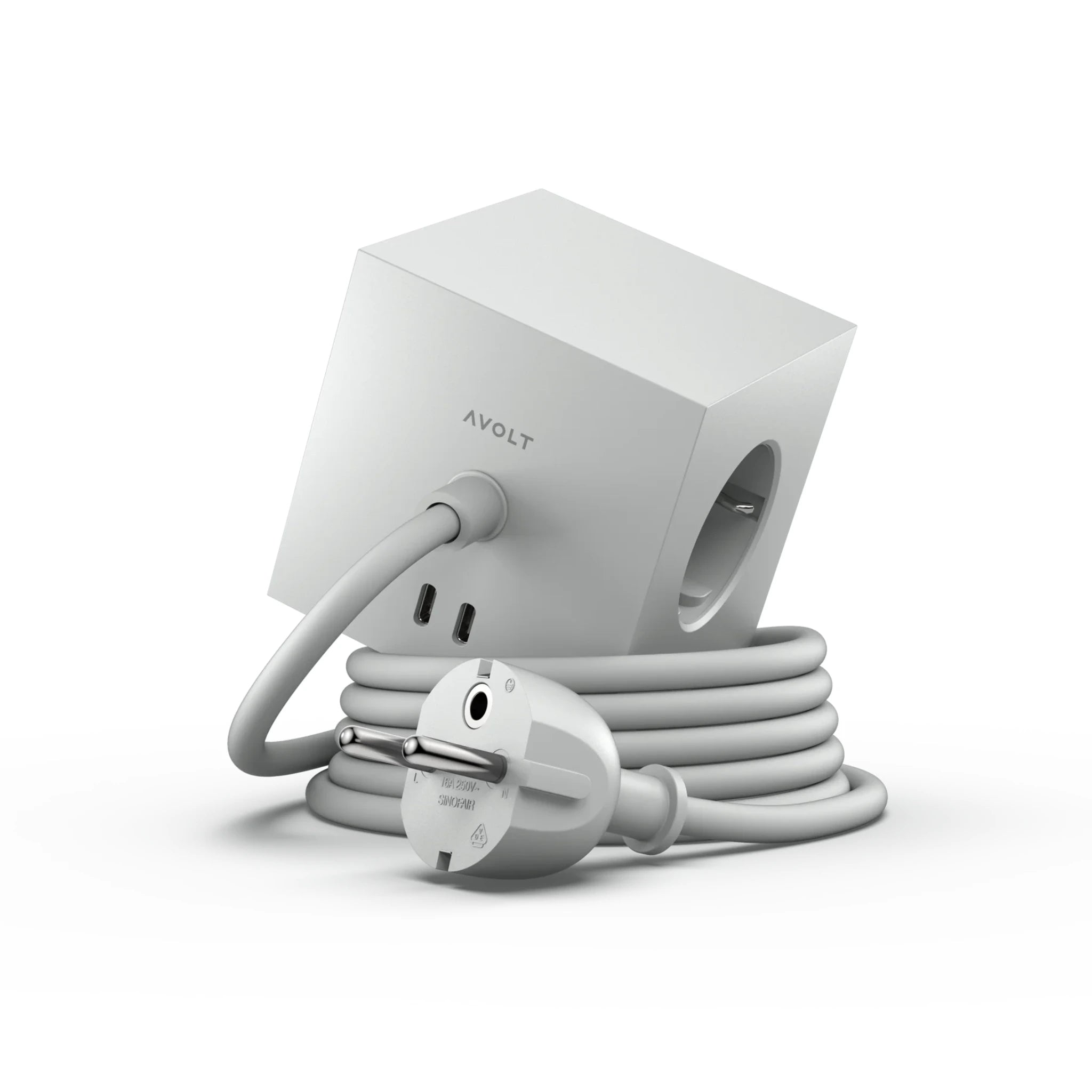 De Avolt Square 1 USB-C Stekkerdoos Gotland Grijs (1,8 m) is een grijze, kubusvormige stekkerdoos met meerdere stopcontacten, USB-poorten inclusief USB-C, een spiraalsnoer en het AVOLT-logo op de zijkant.