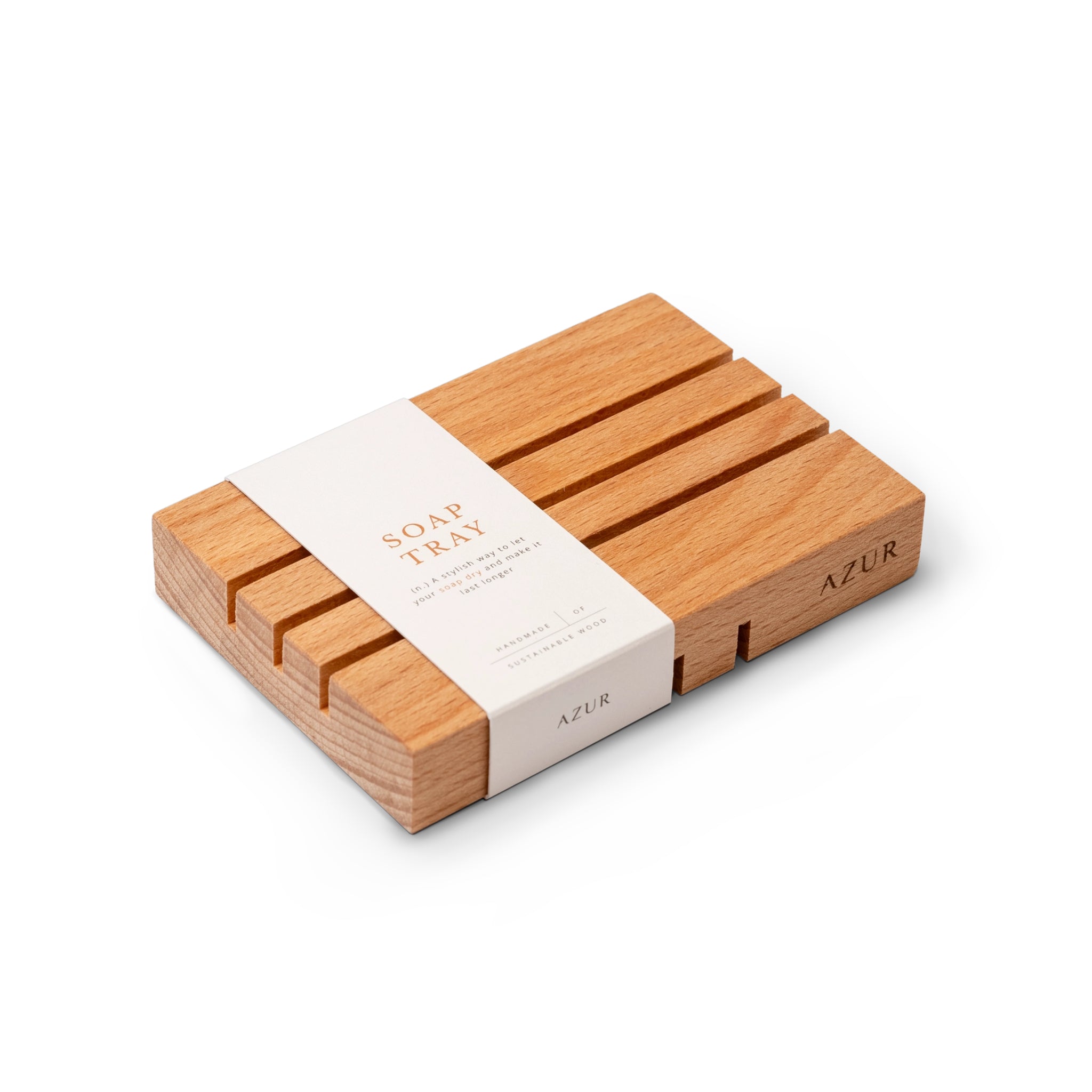De Azur Houten Zeephouder van Azur is een rechthoekig zeepbakje van beukenhout met parallelle groeven, een natuurlijke afwerking en een eenvoudig ontwerp. Verpakt in een witte band met de tekst 'Soap Tray' en 'Azur', is het ideaal voor elk stuk zeep.