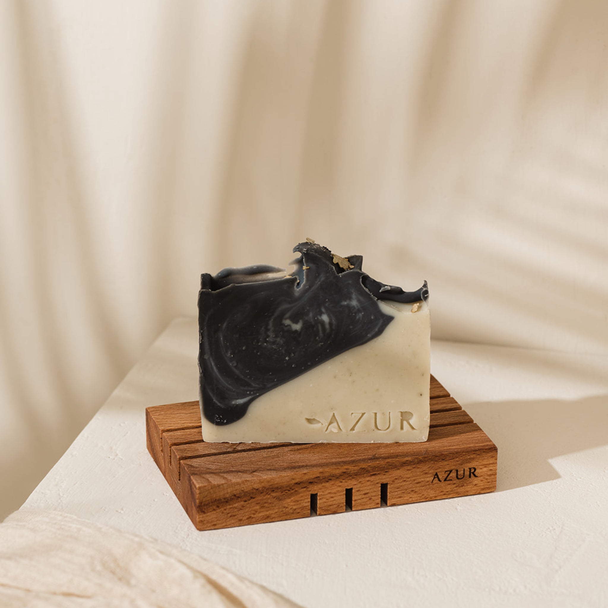 Een rechthoekige staaf Azur Wild Woods Natuurlijke Zeep, gegraveerd met AZUR, rust op een bijpassende houten schaal met hetzelfde merk, tegen een zacht verlichte neutrale achtergrond.