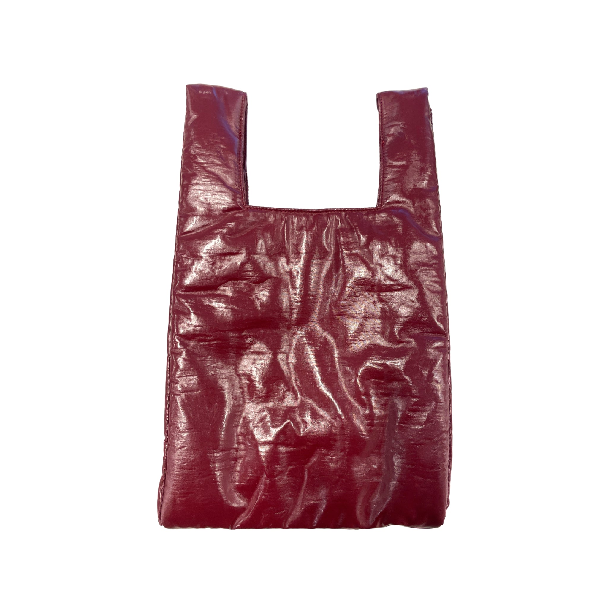 De Caro Antwerp Handtas Chubby Barolo Bordeaux, een glanzende, gekreukelde donkerrode pofzak met twee hengsels, is afgebeeld tegen een effen witte achtergrond.