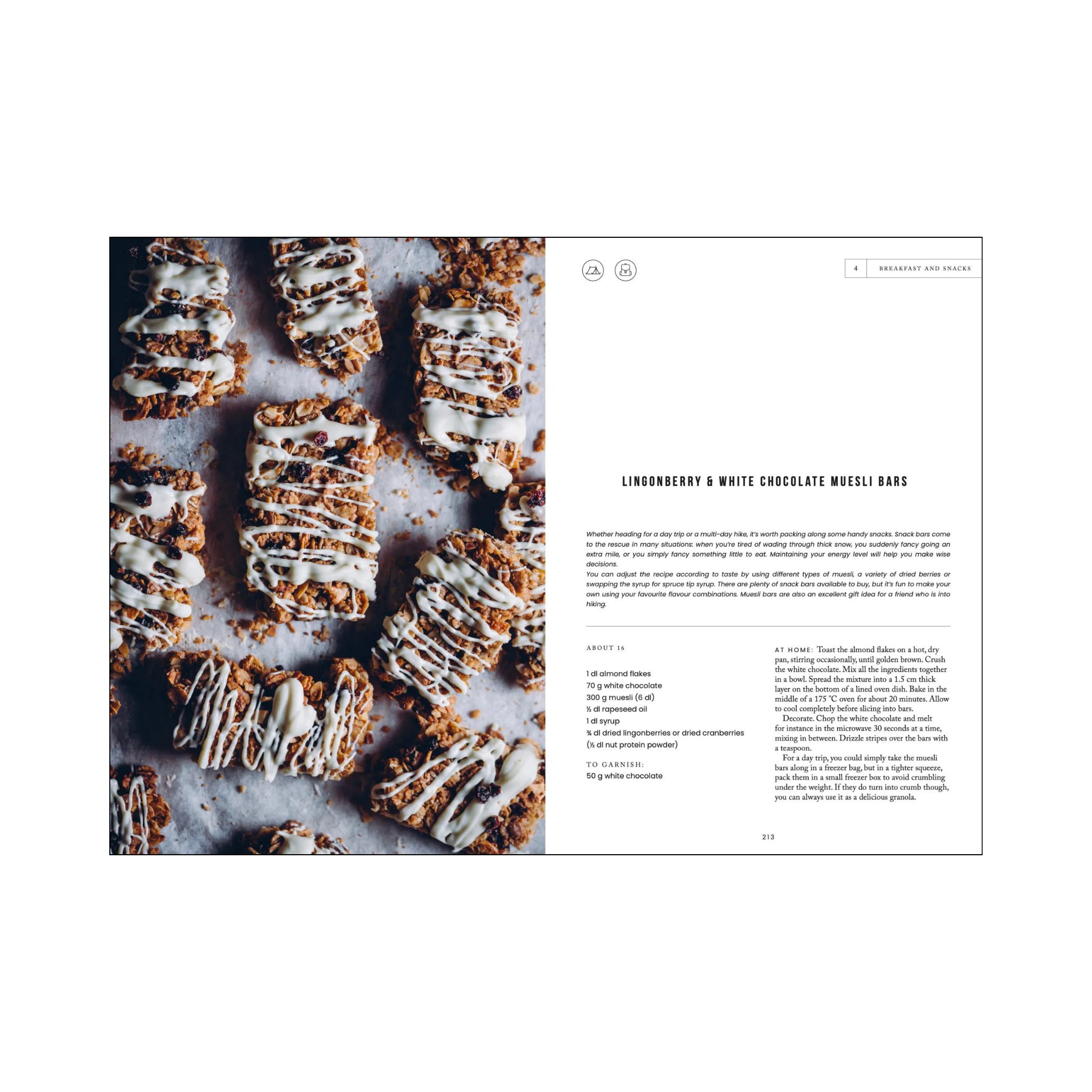 Een platte leg van gesneden mueslirepen overgoten met witte chocolade drizzle aan de linkerkant, en een recept voor Lingonberry & White Chocolate Mueslirepen uit Cozy Publishing Food in the Woods Kookboek van Cozy Publishing aan de rechterkant.