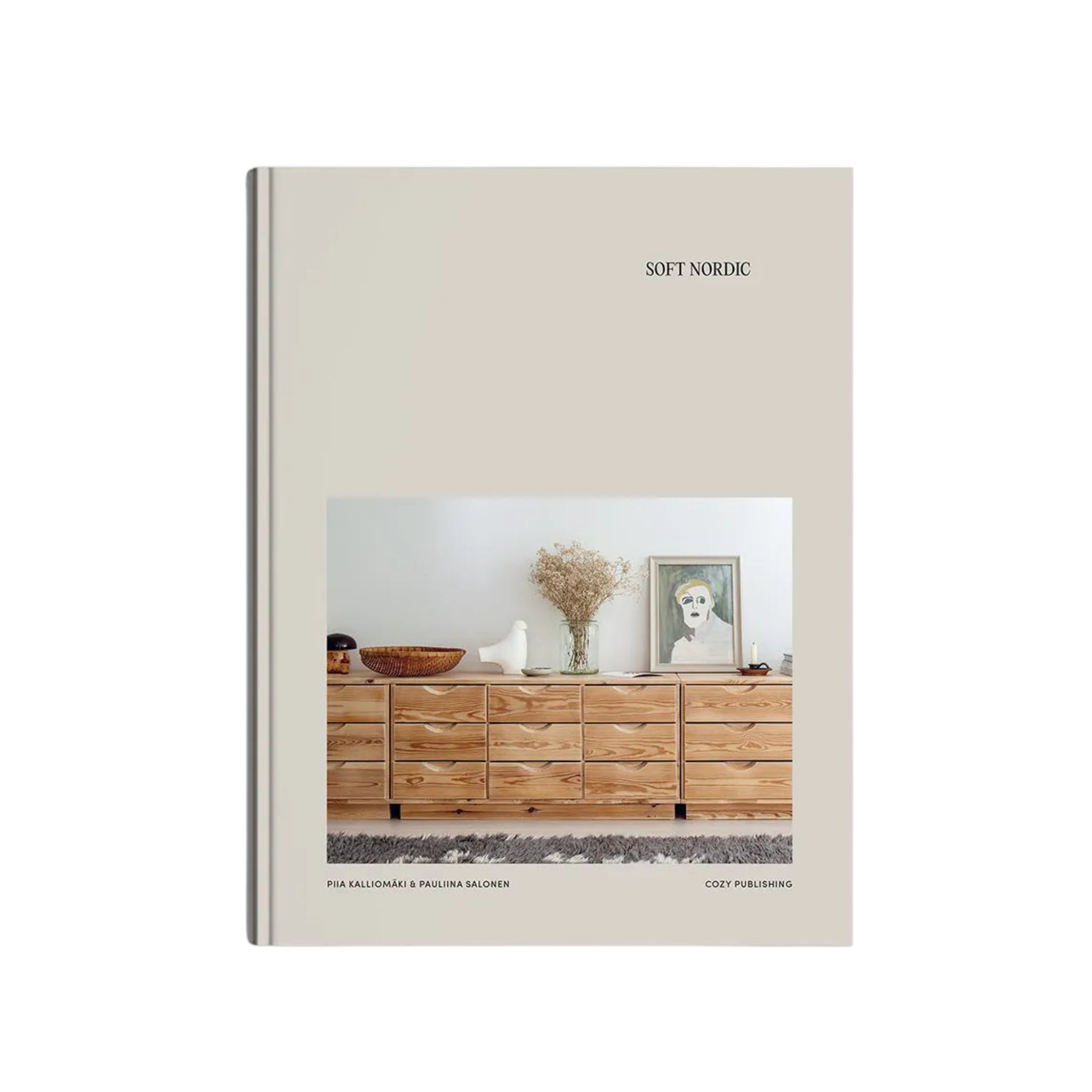 Het Cozy Publishing Soft Nordic Boek van Cozy Publishing toont een minimalistisch houten dressoir met decoratieve items, die de Scandinavische stijl belichamen - een ideale aanvulling op elke collectie salontafelboeken.