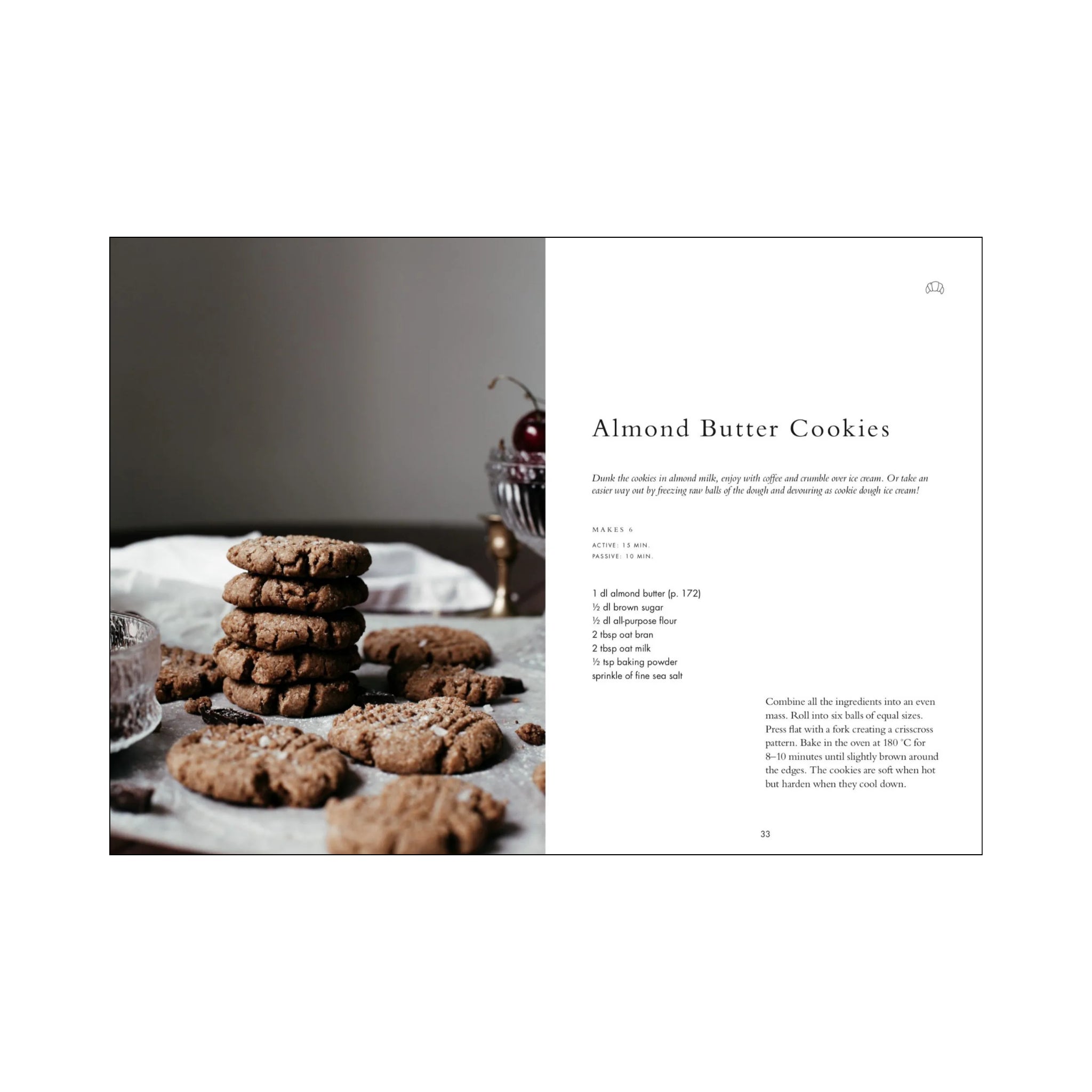 Een pagina uit het Cozy Publishing Wonderful Morning Kookboek toont een amandelboterkoekjesrecept, met aan de ene kant een koekjesstapel en verspreide lekkernijen en aan de andere kant ontbijt recepten plus instructies op een kraakheldere witte achtergrond.