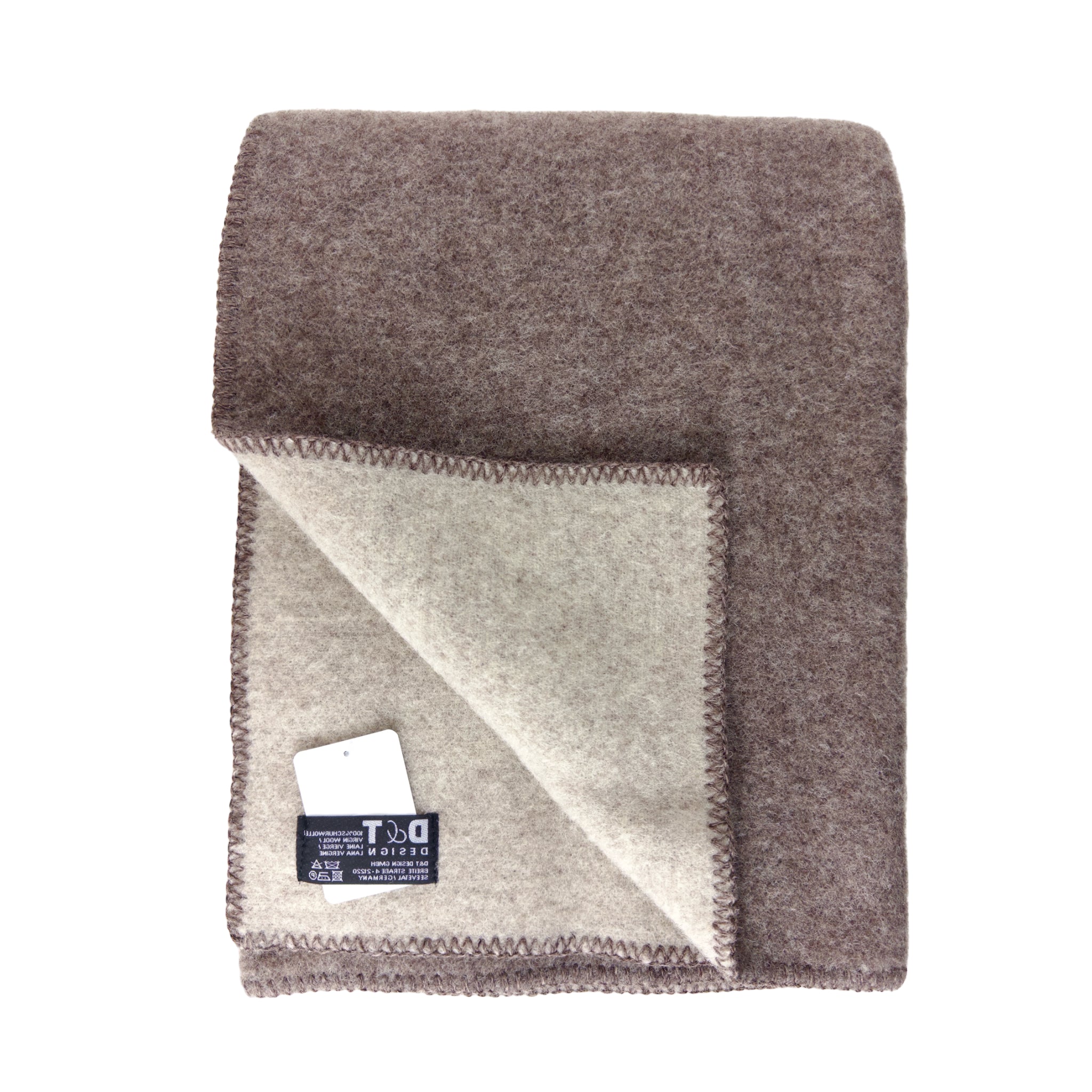 De D&T Design Doubleface Plaid Wol Bruin/Beige 130/180 is een gevouwen wollen deken met een bruine buitenkant, lichtbeige binnenkant, gestikte randen en een zichtbaar D&T Design label op de binnenhoek.