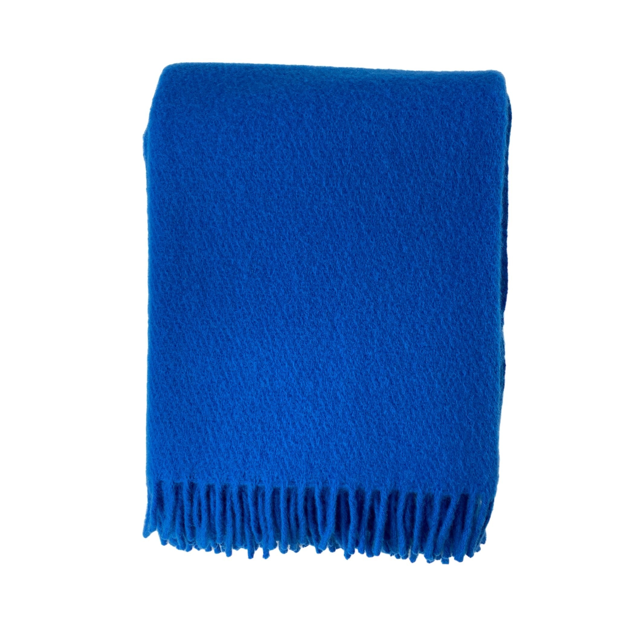 De D&T Design Plaid Wol Blauw 130/180, een zuiver wollen blauwe deken met franjes van D&T Design, is netjes gevouwen en afgebeeld op een witte achtergrond.