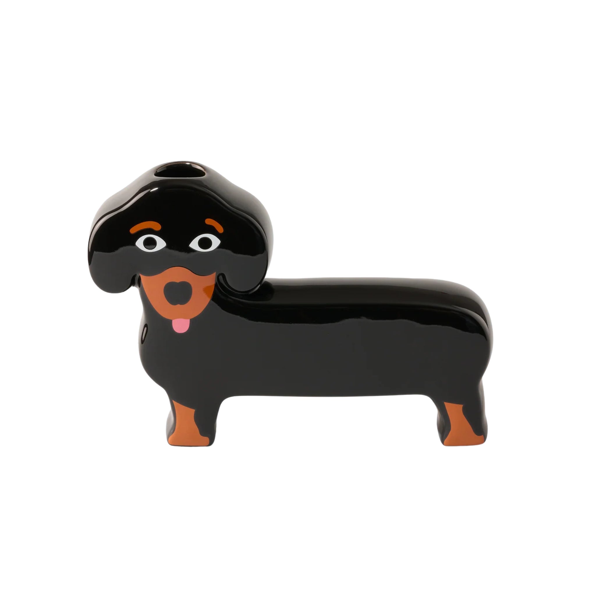 De Fluid Market Teckel Vaas van Fluid Market is een vaas van keramiek in de vorm van een zwarte teckel met bruine details, witte ogen en een roze tong. De vaas heeft een opening aan de bovenkant, waardoor hij perfect is voor unieke woonaccessoires.