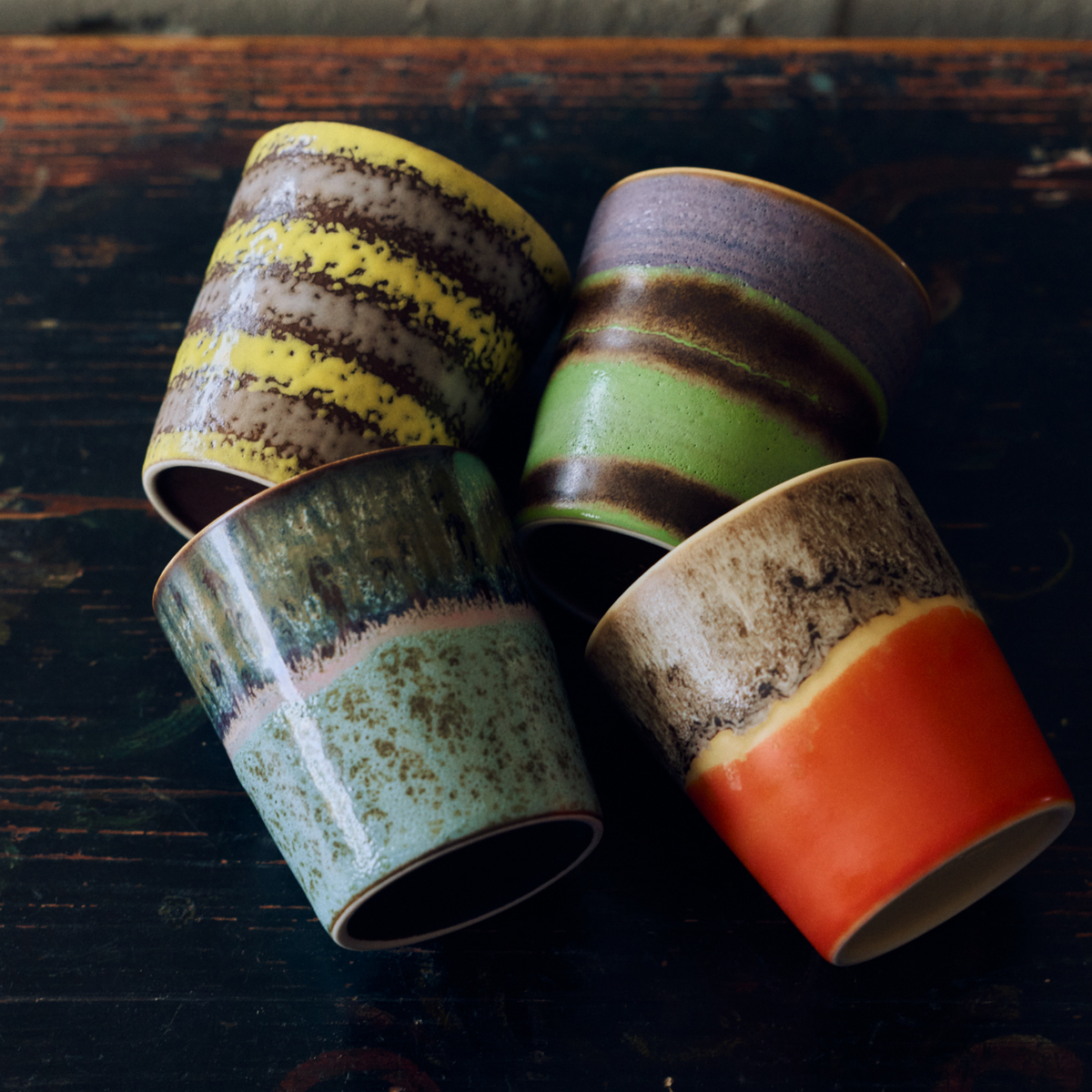 HK Living 70s Ceramics Koffiekoppen Layers, Mochi, Birthstone en Fierce liggend op een donkere houten ondergrond