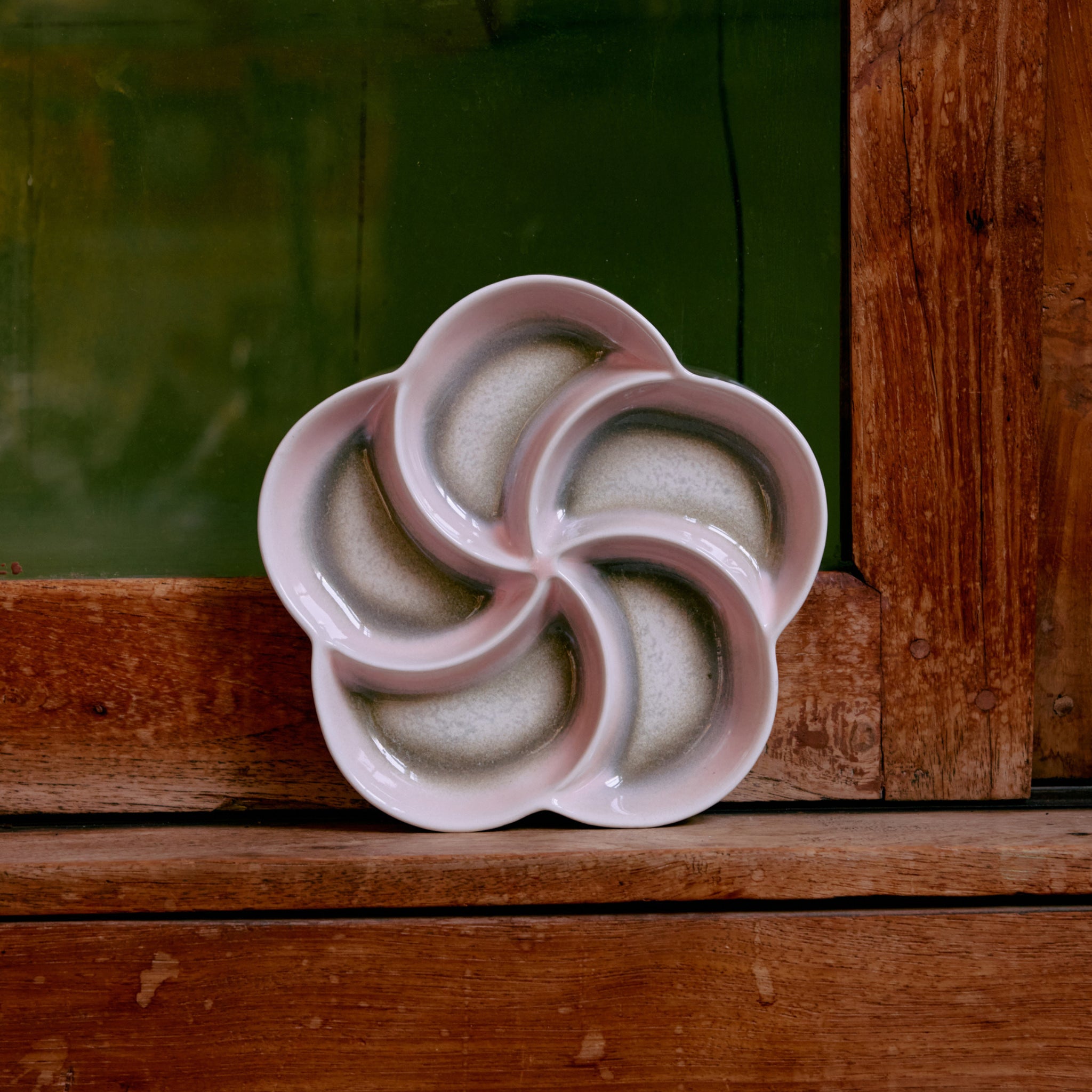 De HK Living 70s Ceramics Snack Schaal Muse heeft vijf bloembladvormige compartimenten in een bloemmotief en weerspiegelt de iconische stijl van de retro-collectie van het merk.