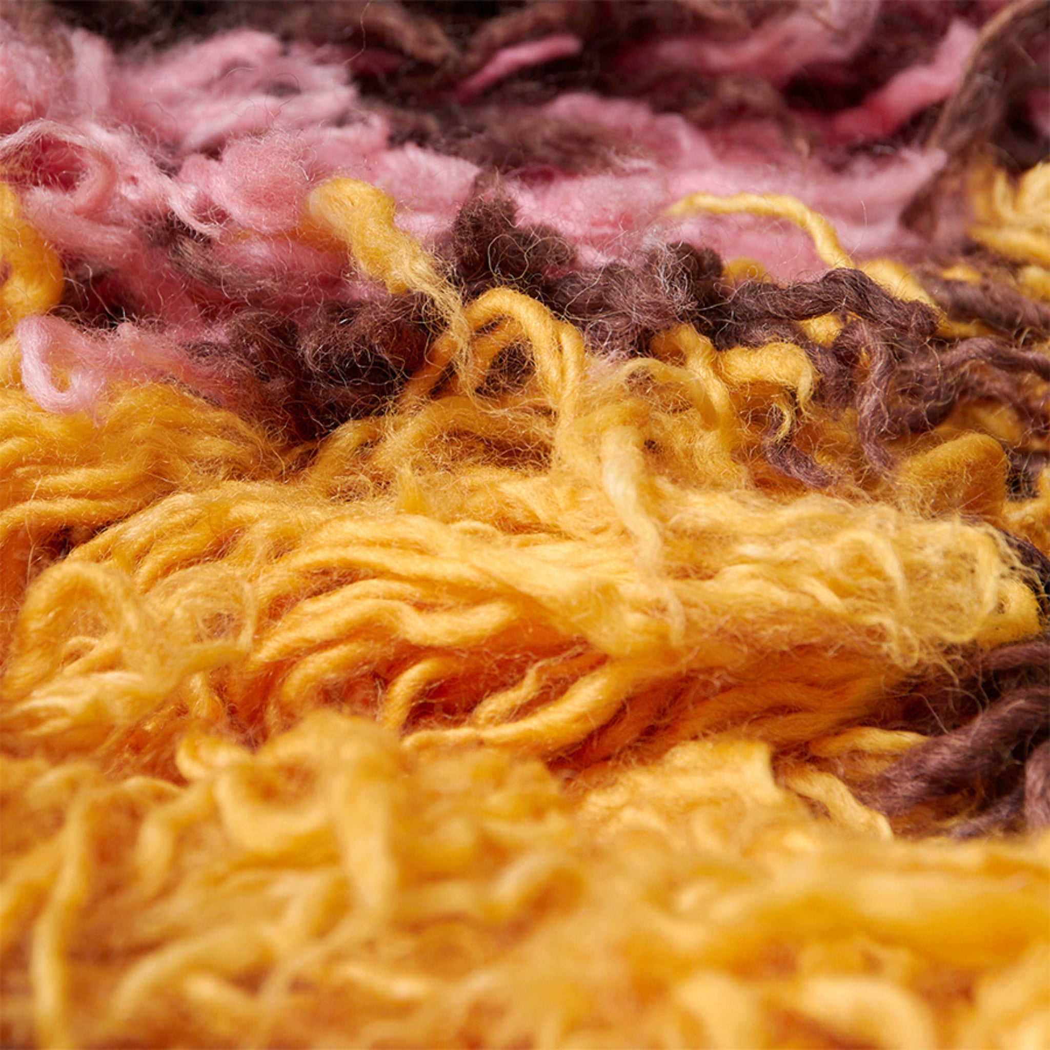 Close-up van zacht, gestructureerd veelkleurig garen in geel, roze en bruin creëert een pluizige look die doet denken aan de HK Living Fluffy Tapijt South Beach 360/80.