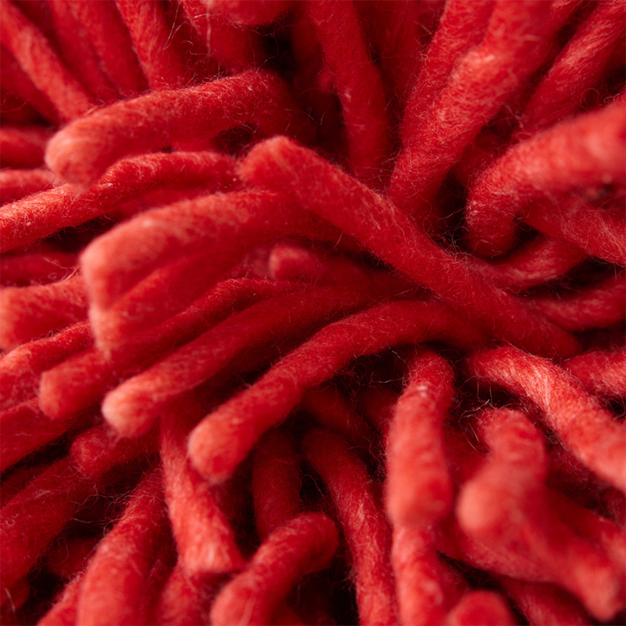 Close-up van kersenrood, zachte, dicht opeengepakte vezels - waarschijnlijk onderdeel van de HK Living Rugged Kussen Kersenrood 50/50 van HK Living.