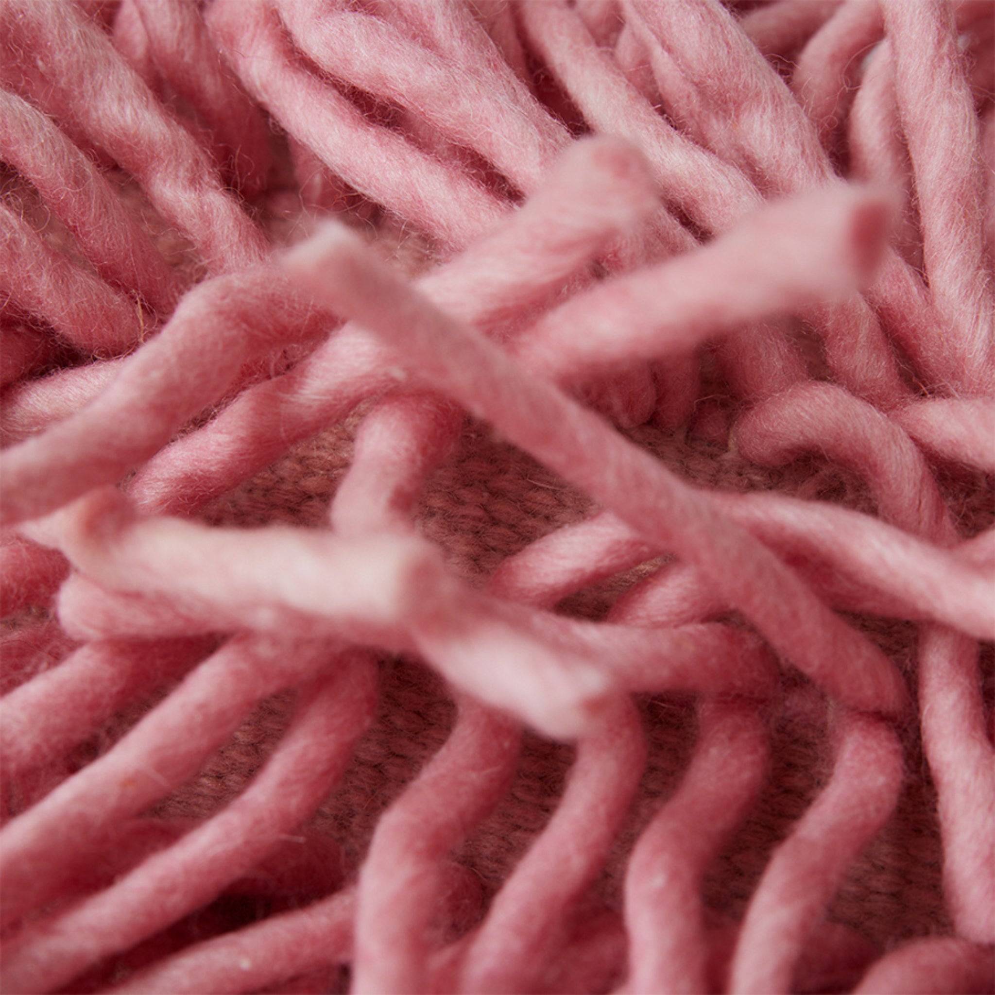 Close-up van dik, zacht roze garen in een los, hoogpolig patroon benadrukt de donzige textuur en tactiele details van het HK Living Rugged Kussen Roze 70/45 kussen.