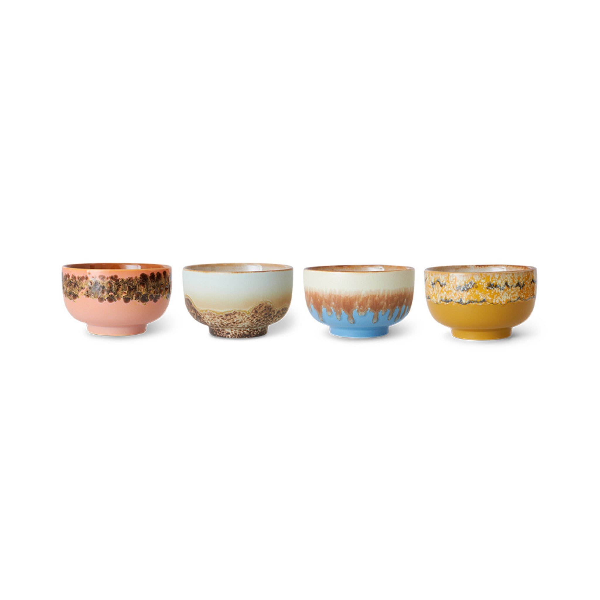 Vier HK Living 70s Ceramics Noodle Kom Seabreeze kommen (set van 4), elk met unieke kleuren en patronen: roze met bruine spikkels, lichtblauw met tan, blauw met tan druppels, en mosterdgeel met zwarte spikkels.