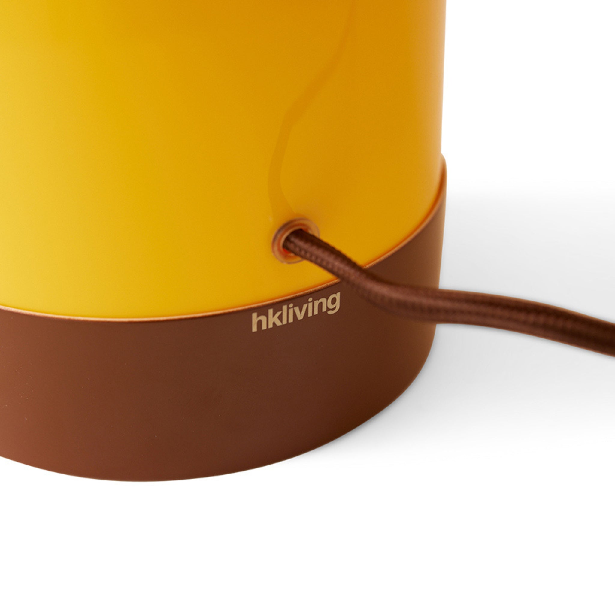 Close-up van de voet van de HK Living Lounge Tafellamp Butterscotch met een bruin netsnoer aangesloten; "HK Living" is gedrukt op het bruine gedeelte. Geschikt voor gebruik met een dimbare E27 LED lamp.