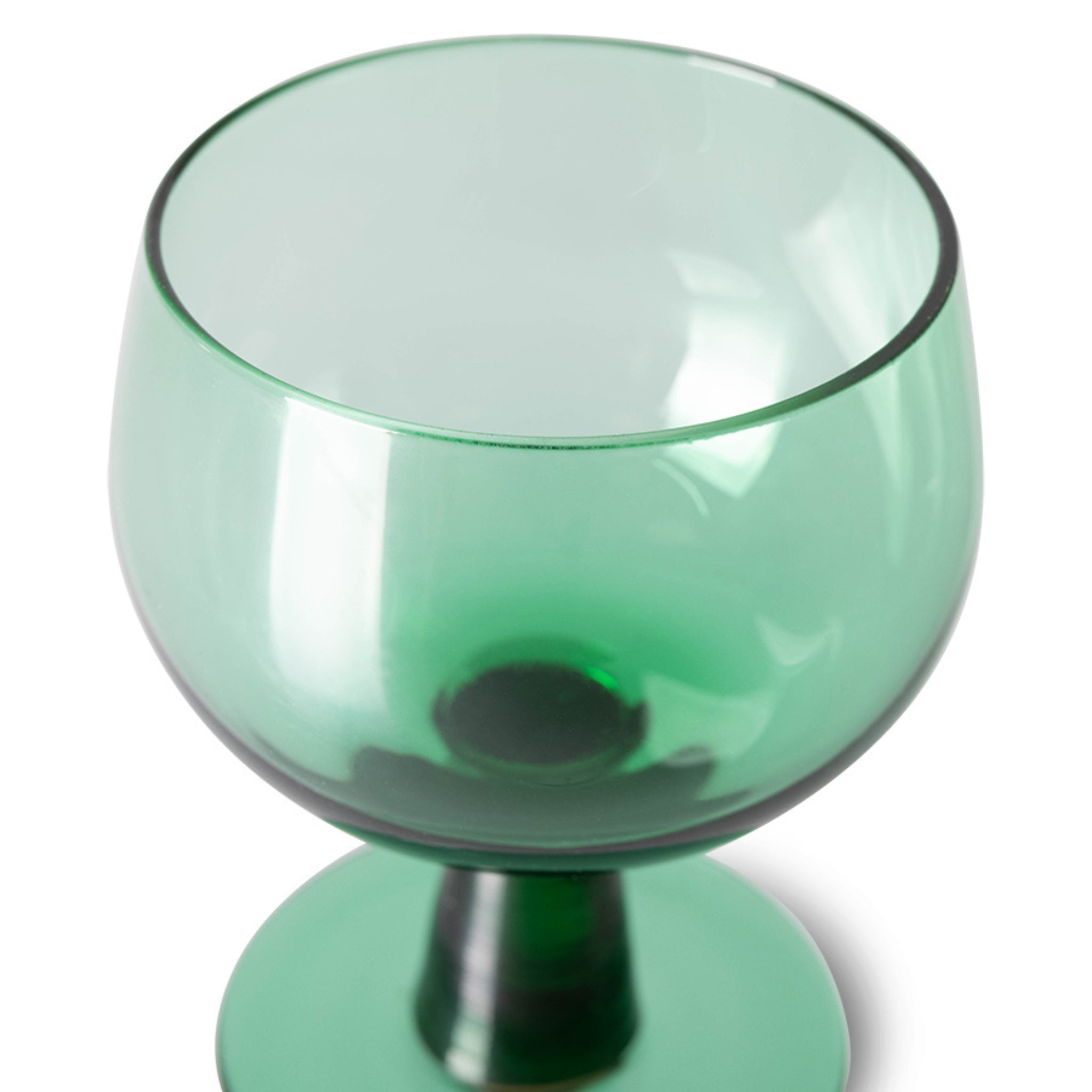 De HK Living The Emeralds Wijnglas Laag Groen 4 st. heeft smaragdgroene glazen met brede, ronde schalen en stevige stelen, afgebeeld tegen een witte achtergrond.