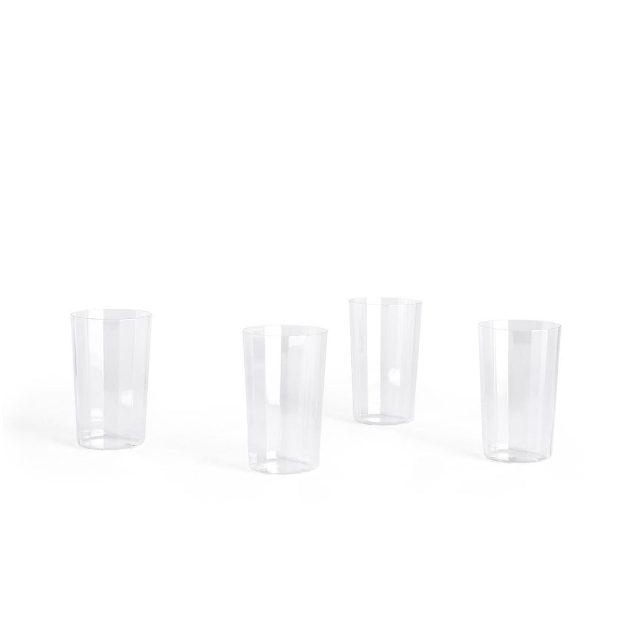 Vier heldere Hay Angle Longdrink Glazen van Hay zijn gelijkmatig verdeeld op een witte achtergrond en weerspiegelen de verfijnde eenvoud van elegant glaswerk. Set bestaat uit 4 stuks.