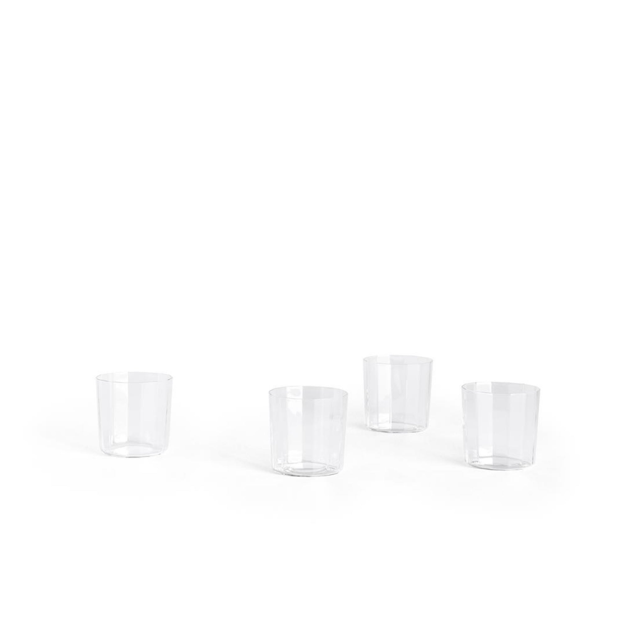 Vier Hay Angle Waterglazen 4 st. van Hay, gemaakt van kristallijn glas, zijn gegroepeerd op een witte achtergrond met royale lege ruimte erboven voor een elegante uitstraling.