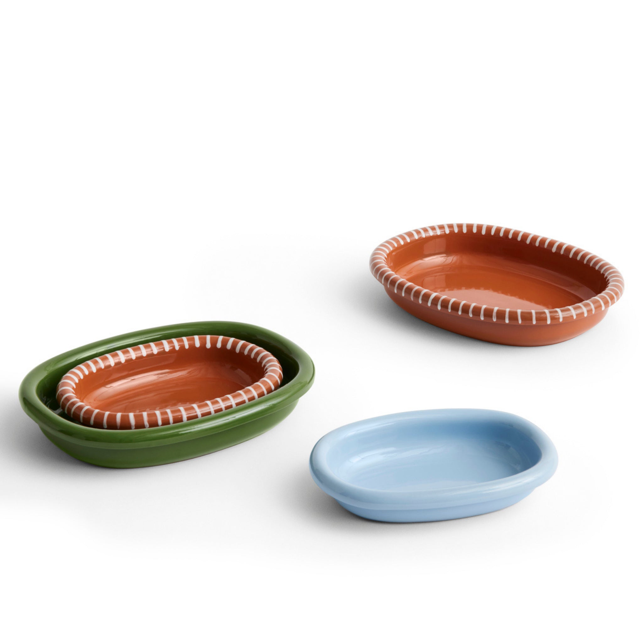 Drie Hay Barro Ovale Schalen Terracotta 27/36 - een groene met een genestelde oranje schaal, een oranje met witte rand en een lichtblauwe van Hay staan op een witte achtergrond.