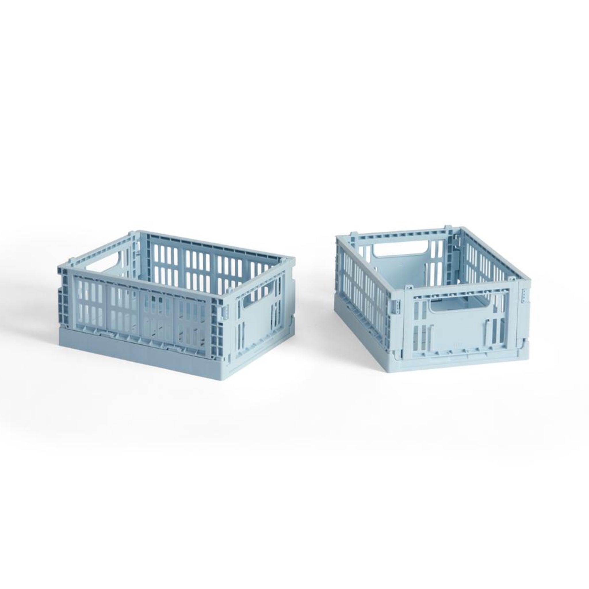 Twee Hay Kleur Krat Mini Lichtblauw opbergkratten van Hay, gemaakt van gerecycled plastic met open latten aan de zijkanten en handgrepen, staan naast elkaar op een witte achtergrond.