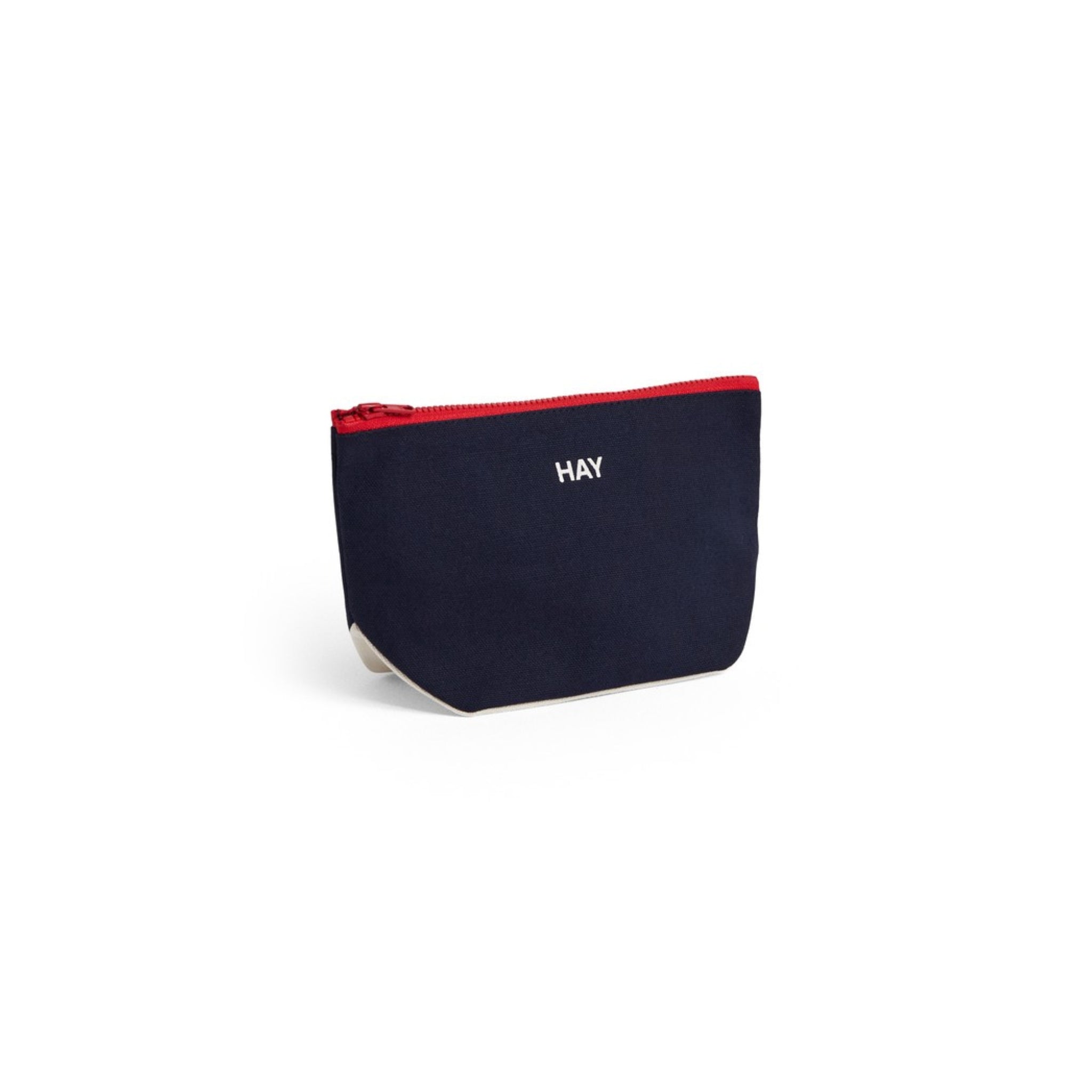 Het Hay Multi Opbergzakje Midnight Blauw S is een klein opbergtasje van Hay, met een middernachtblauwe kleur, rode rits, witte "HAY" print op de voorkant en een eenvoudig Scandinavisch ontwerp voor een minimalistische esthetiek.