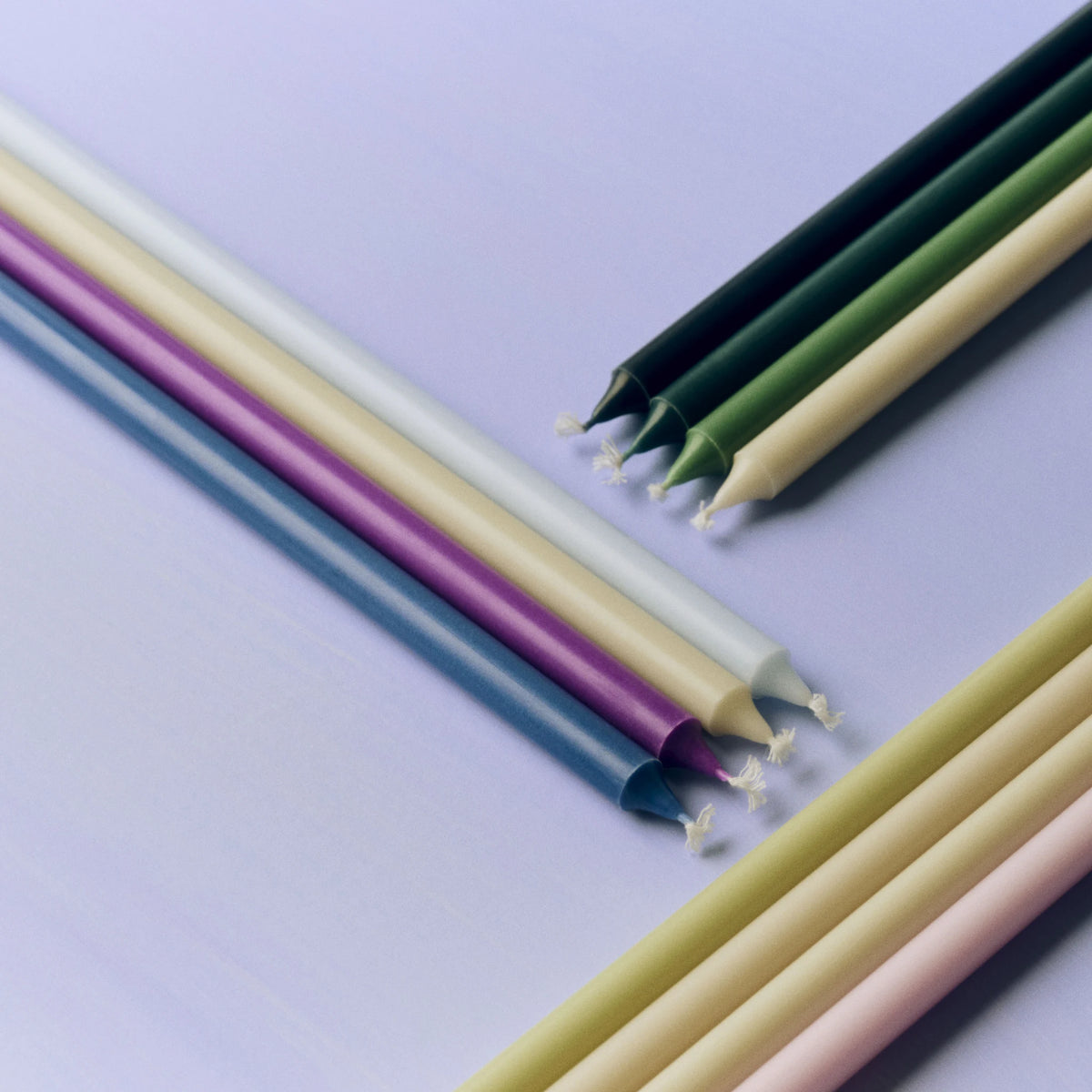 Bovenaanzicht van Hay Slim Kaarsen op een lila ondergrond, met links de set Paars en Blauw: gebroken wit, lichtblauw, paars en blauw.