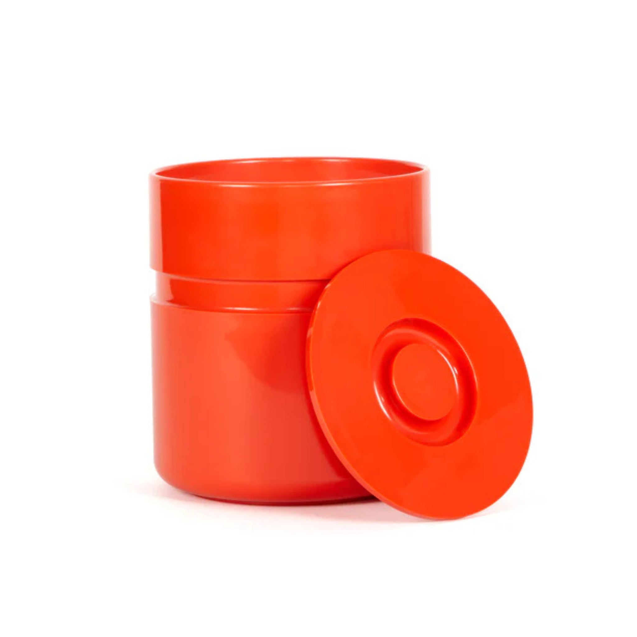 De Heller Asti Ijsemmer Oranje, een fel oranje cilindervormige ijsemmer van Heller, staat open met het bijpassende ronde deksel ernaast op een witte achtergrond, geïnspireerd door de iconische ontwerper Sergio Asti.