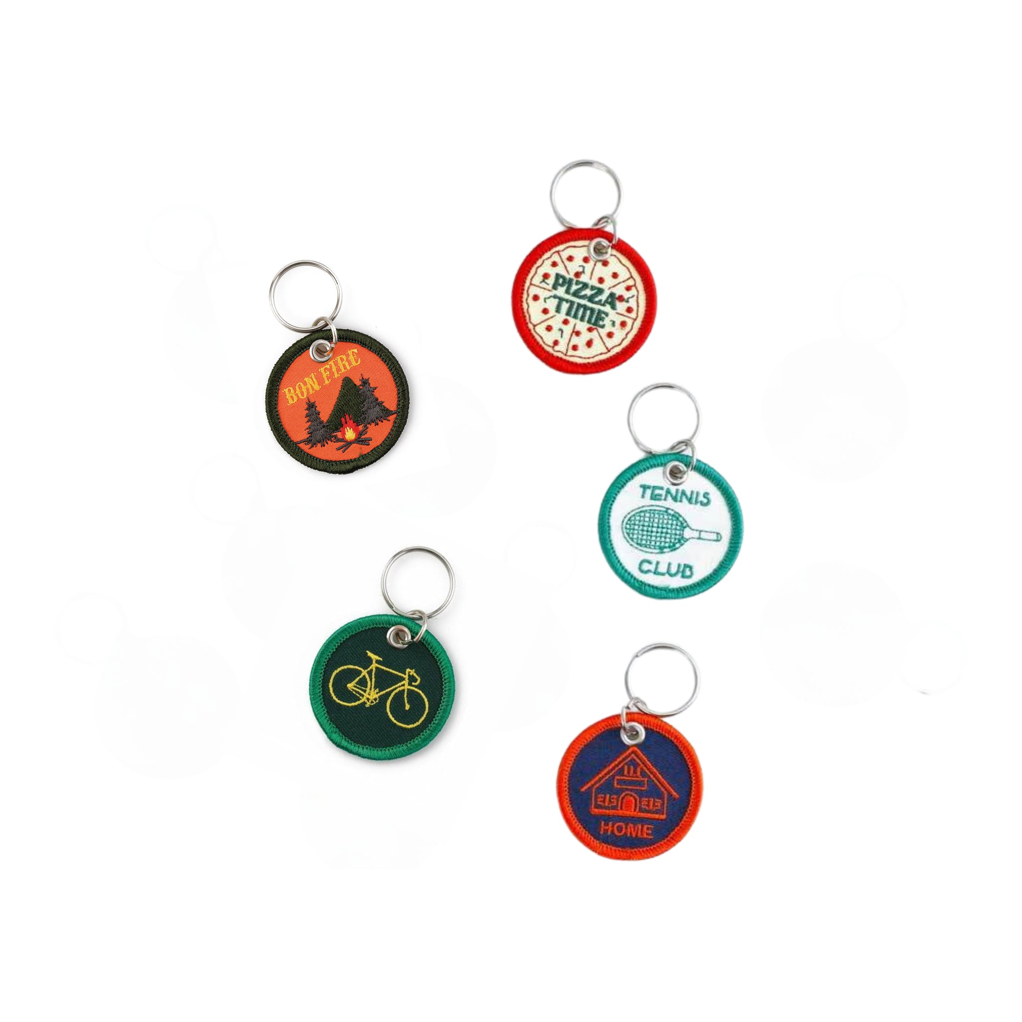 De Hightide Stitch Work Sleutelhanger Pizza is afgebeeld op een witte achtergrond naast andere ronde, retro-stijl geborduurde sleutelhangers van Hightide, elk met unieke ontwerpen zoals een kampvuur, tennisracket, fiets en huis met het label HOME.