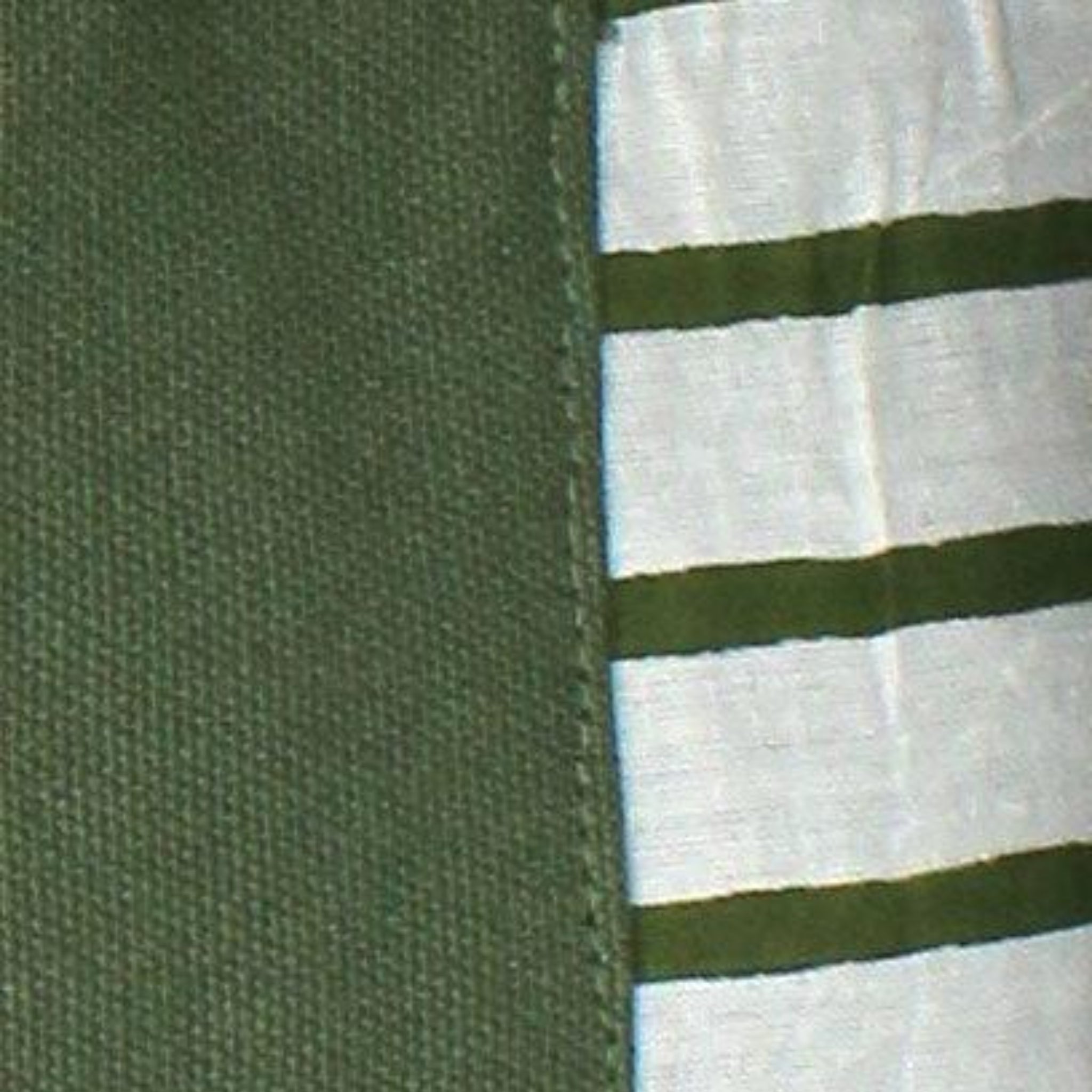 Een close-up van Hindbag's Leon Toilettas Olijfgroen laat de duurzame biologische katoenen stof zien naast witte stof met groene strepen, wat de kwaliteit materialen benadrukt die perfect zijn voor een toilettas.