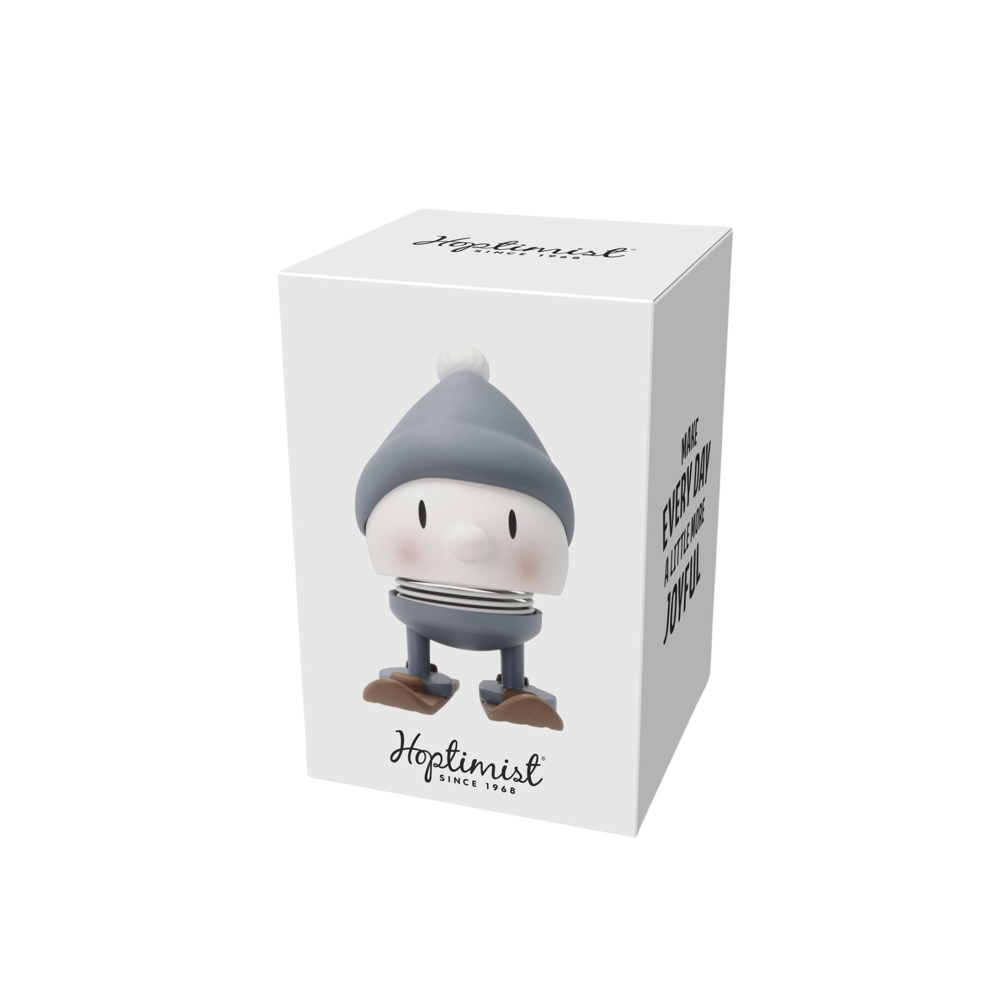 De Hoptimist Ski Bumble S Sky wordt geleverd in een witte doos met een illustratie van het vrolijke figuurtje met grijze hoed, gestreept shirt, blauwe broek en bruine schoenen - ideaal als winterse decoratie of origineel cadeau. Inclusief "Hoptimist" merknaam en slogan.