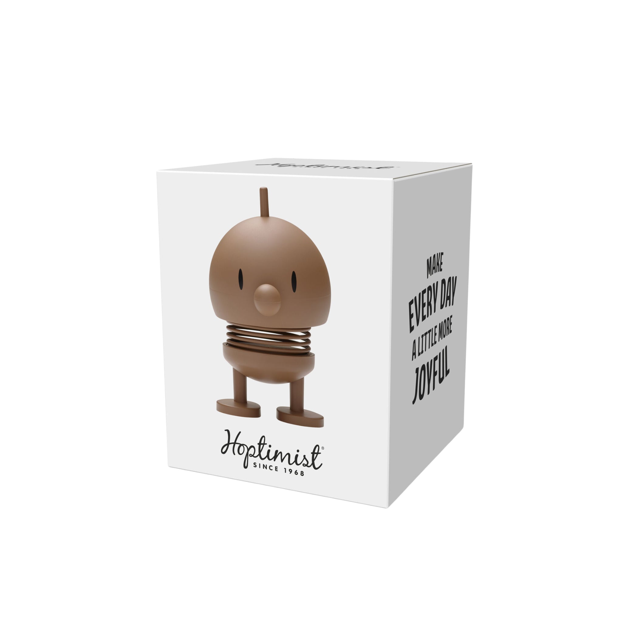 Op een witte doos staat de Hoptimist Zachte Hommel S Chocolade van Hoptimist - een bruin beeldje met een rond lichaam, kleine snavel en veerpoten. Op de doos staat "Hoptimist Since 1968" en "Maak elke dag een beetje vrolijker".