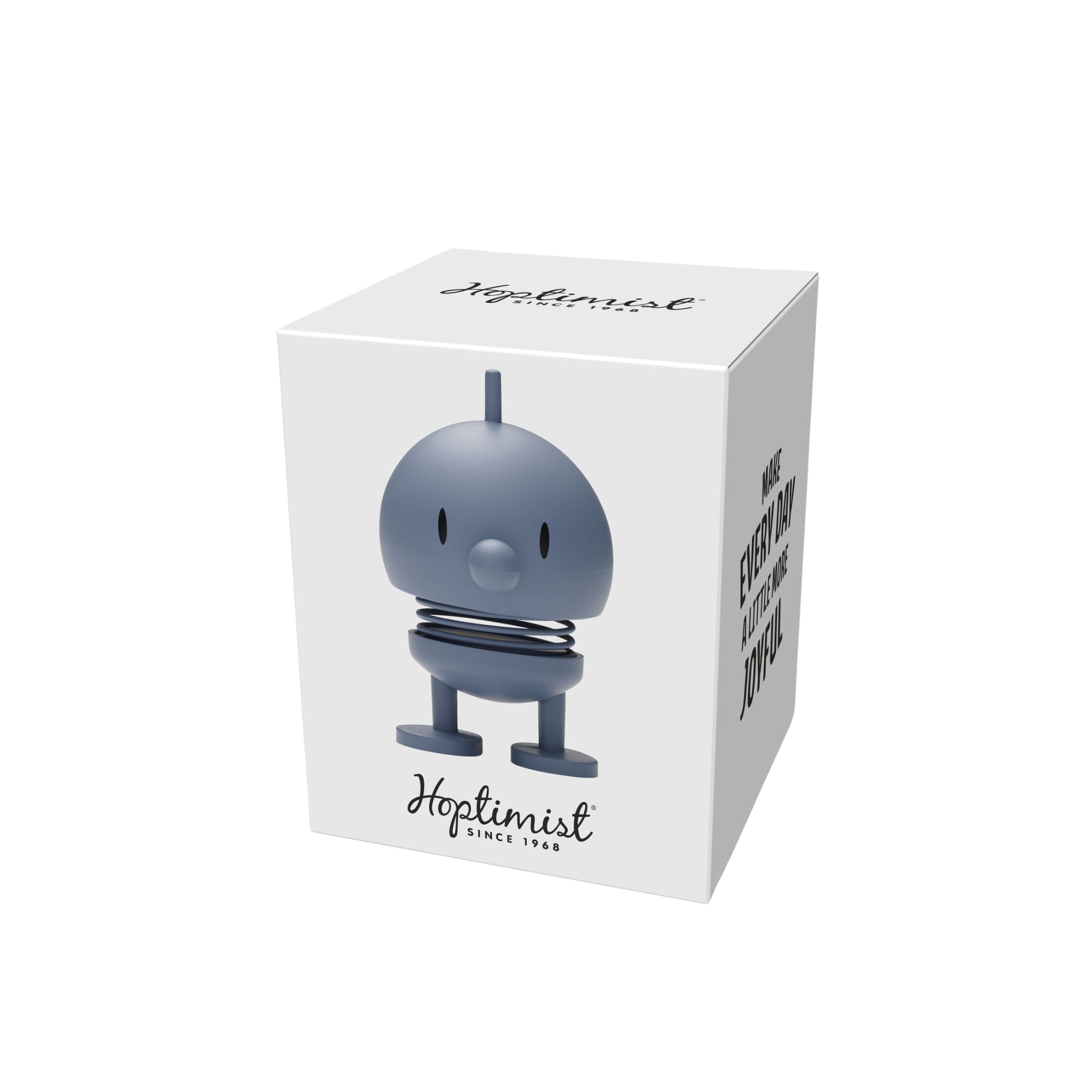 Een witte doos toont een afbeelding van de Hoptimist Soft Bumble S Sky, een blauw, rond beeldje met een snavel en antenne. Met het merk "Hoptimist Since 1968" benadrukt de zijkant het Deense ontwerp met "MAKE EVERY DAY A LITTLE MORE JOYFUL.