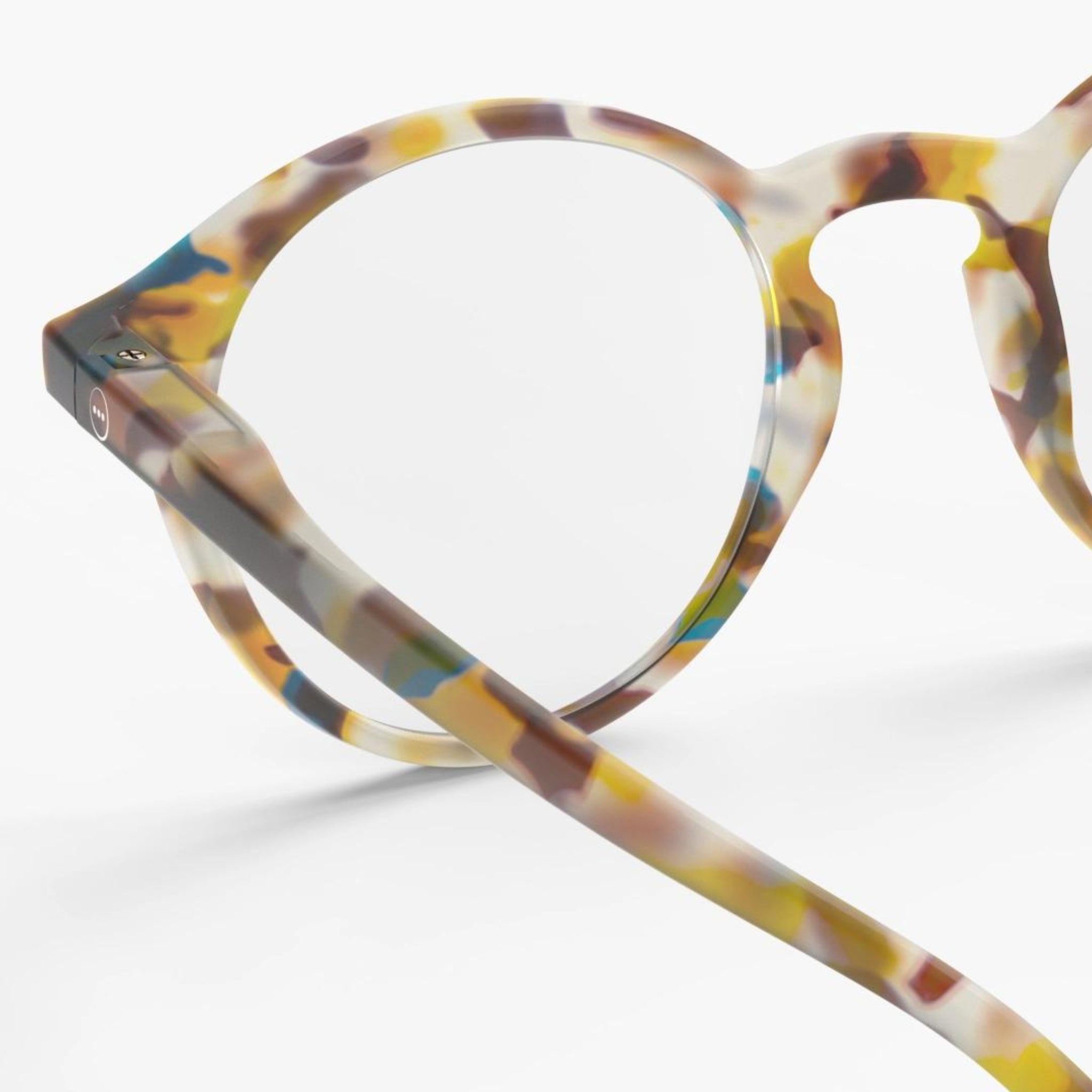 De Izipizi Leesbril #D Blue Tortoise heeft ronde monturen met een doorschijnend, veelkleurig schildpadpatroon in blauw, bruin, geel en wit - perfect om presbyopie stijlvol aan te pakken. Afgebeeld op een witte achtergrond.