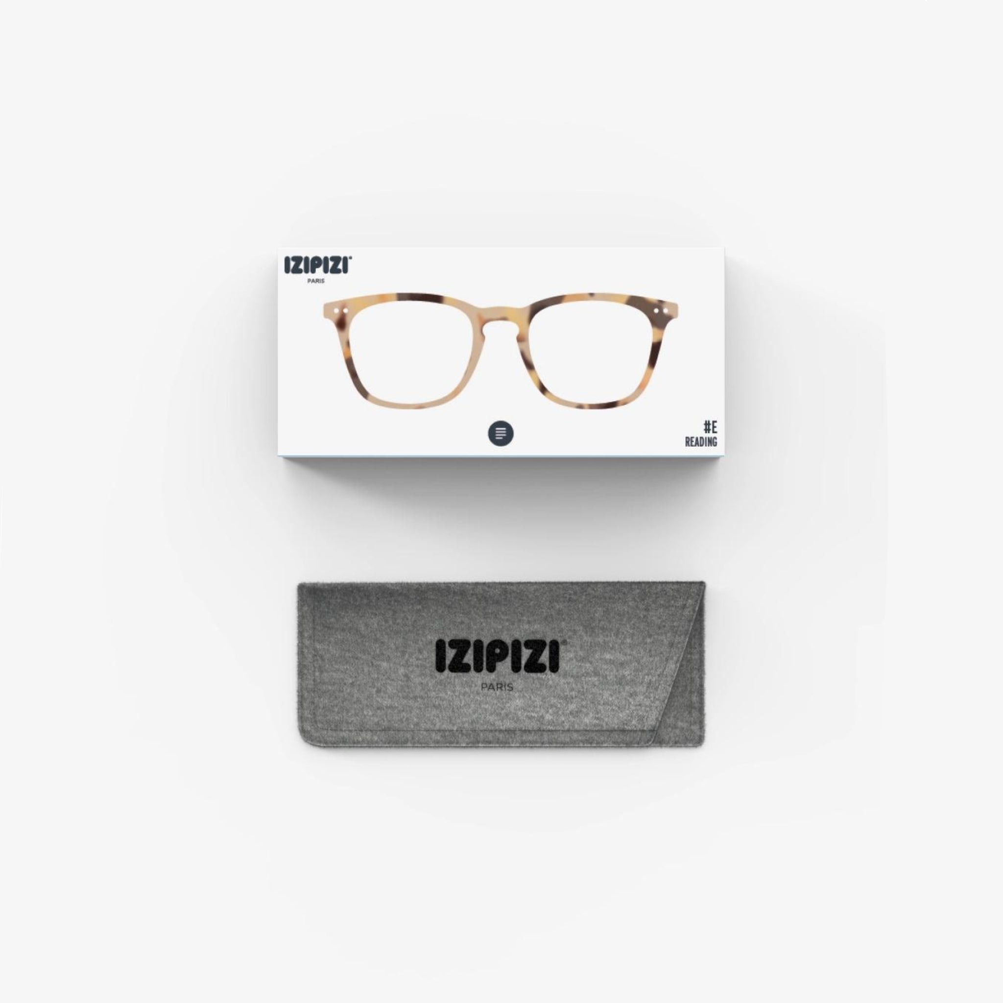 De Izipizi Leesbril #E Light Tortoise van Izipizi, met een stijlvol schildpadmontuur, wordt weergegeven boven een grijze merketui op een witte achtergrond-ideaal als een modieuze leesbril heren dames voor dagelijks lezen.