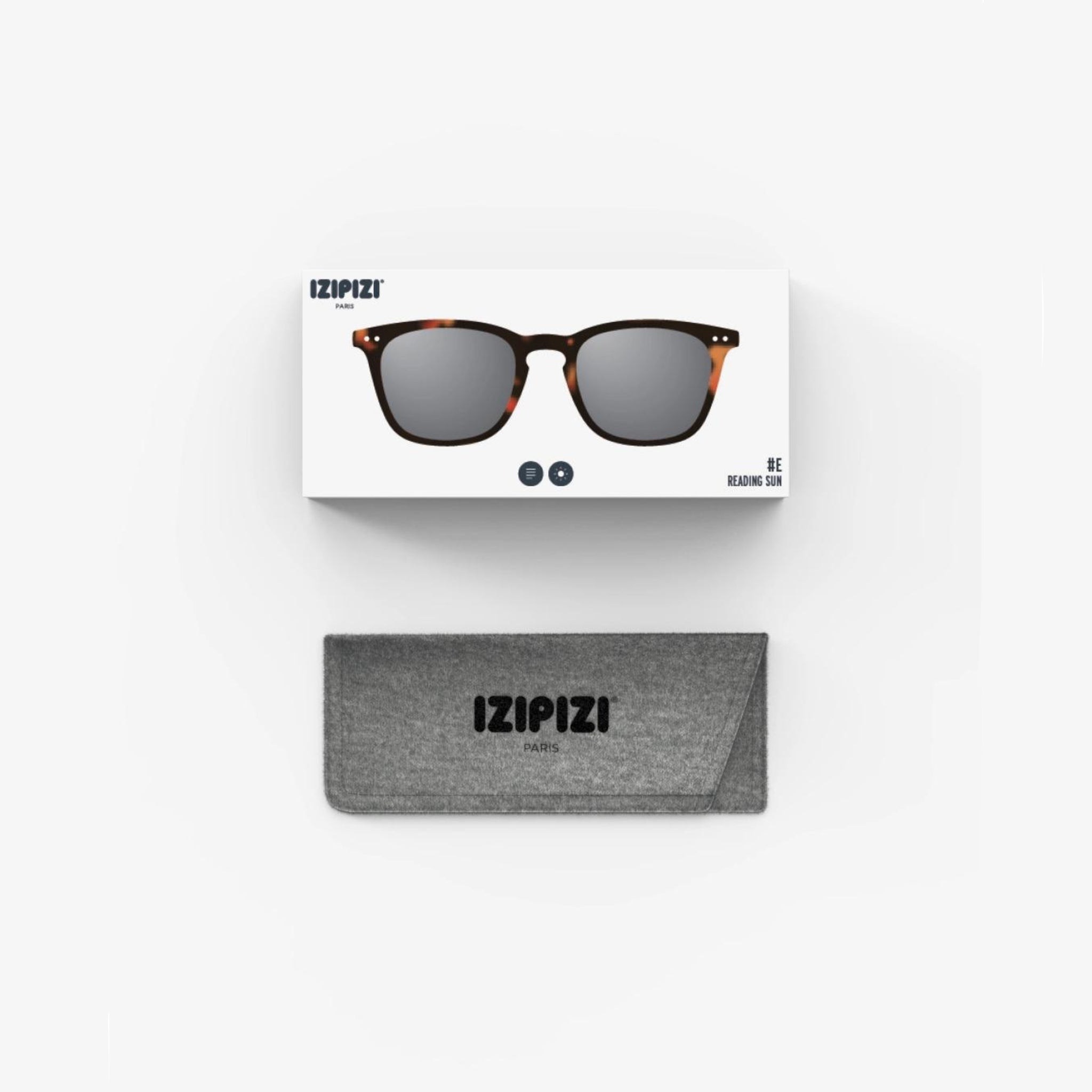 De Izipizi Zonnebril Sterkte #E Tortoise heeft een stijlvol bruin schildpad montuur en wordt geleverd met een grijze IZIPIZI-branded case, beide getoond op een witte achtergrond. Deze modieuze unisex zonnebril biedt uitstekende UV bescherming.