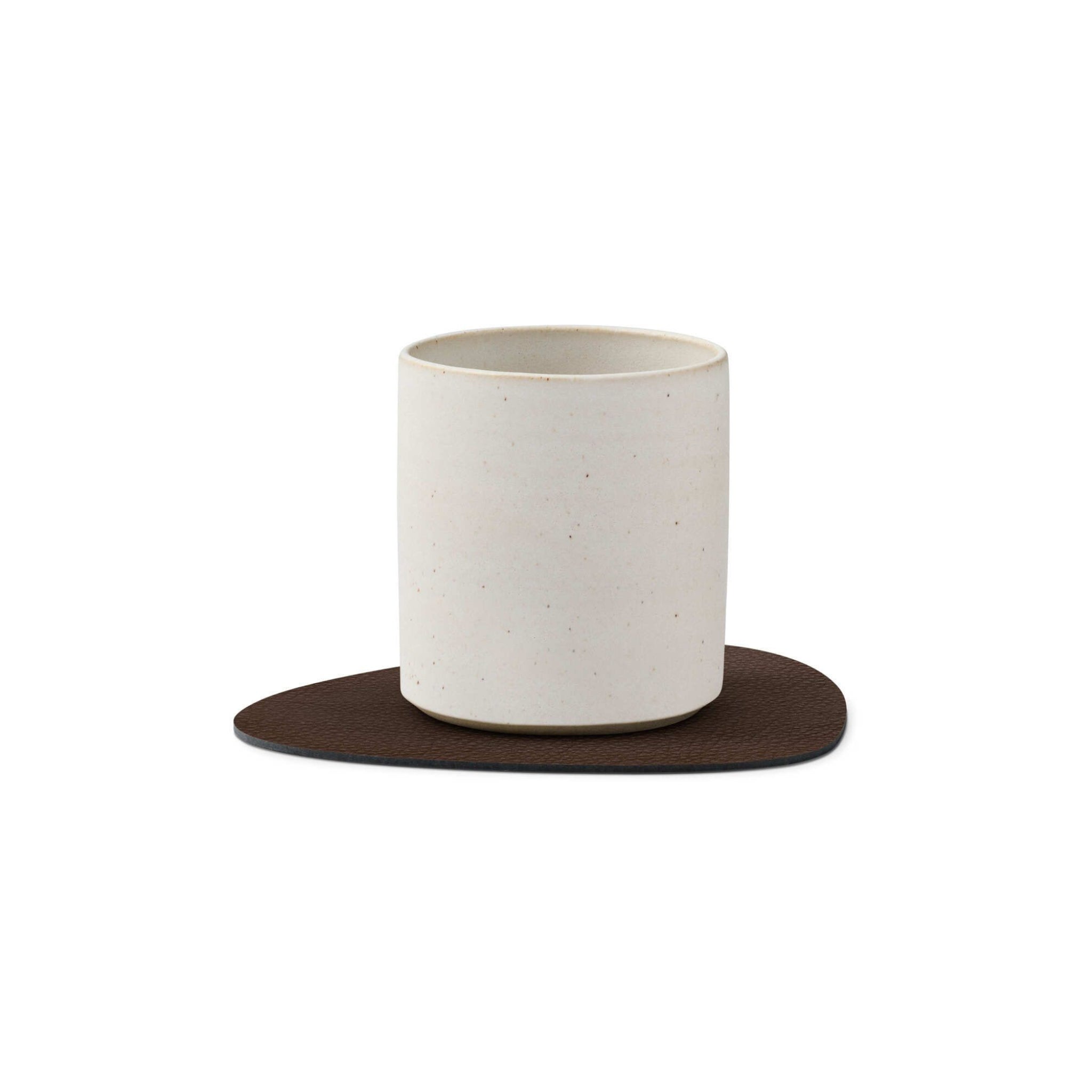 Een eenvoudige, cilindervormige beker van wit keramiek staat op een onderzetter van Lind DNA Serene Onderzetter Curve Hazel 11/13 met een textuur van gerecycled leer, tegen een effen witte achtergrond.