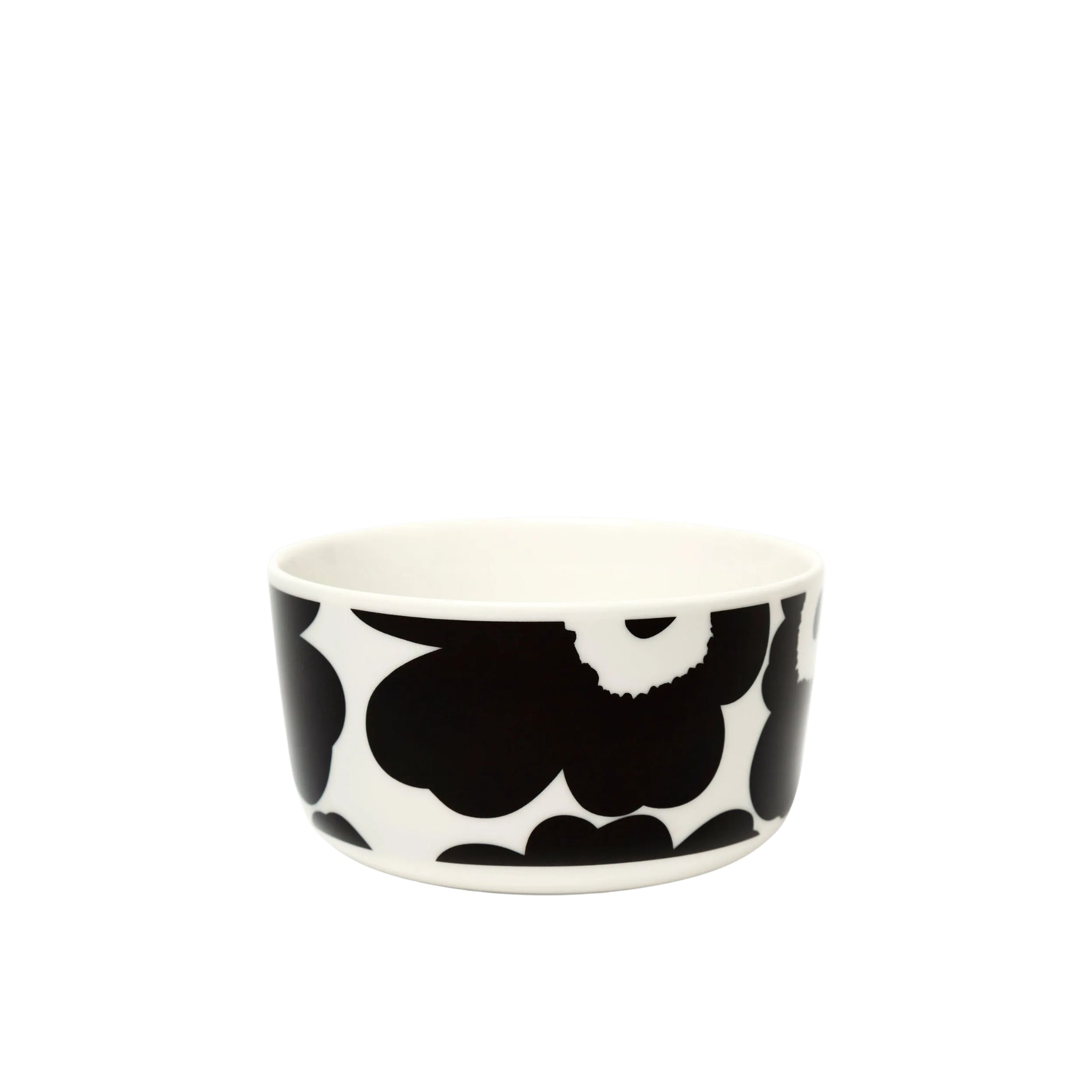 De Marimekko Oiva Unikko Kom Zwart D12,5 is een kom van wit keramiek met Marimekko's opvallende zwarte Unikko bloemenprint op de zijkanten tegen een effen witte achtergrond.