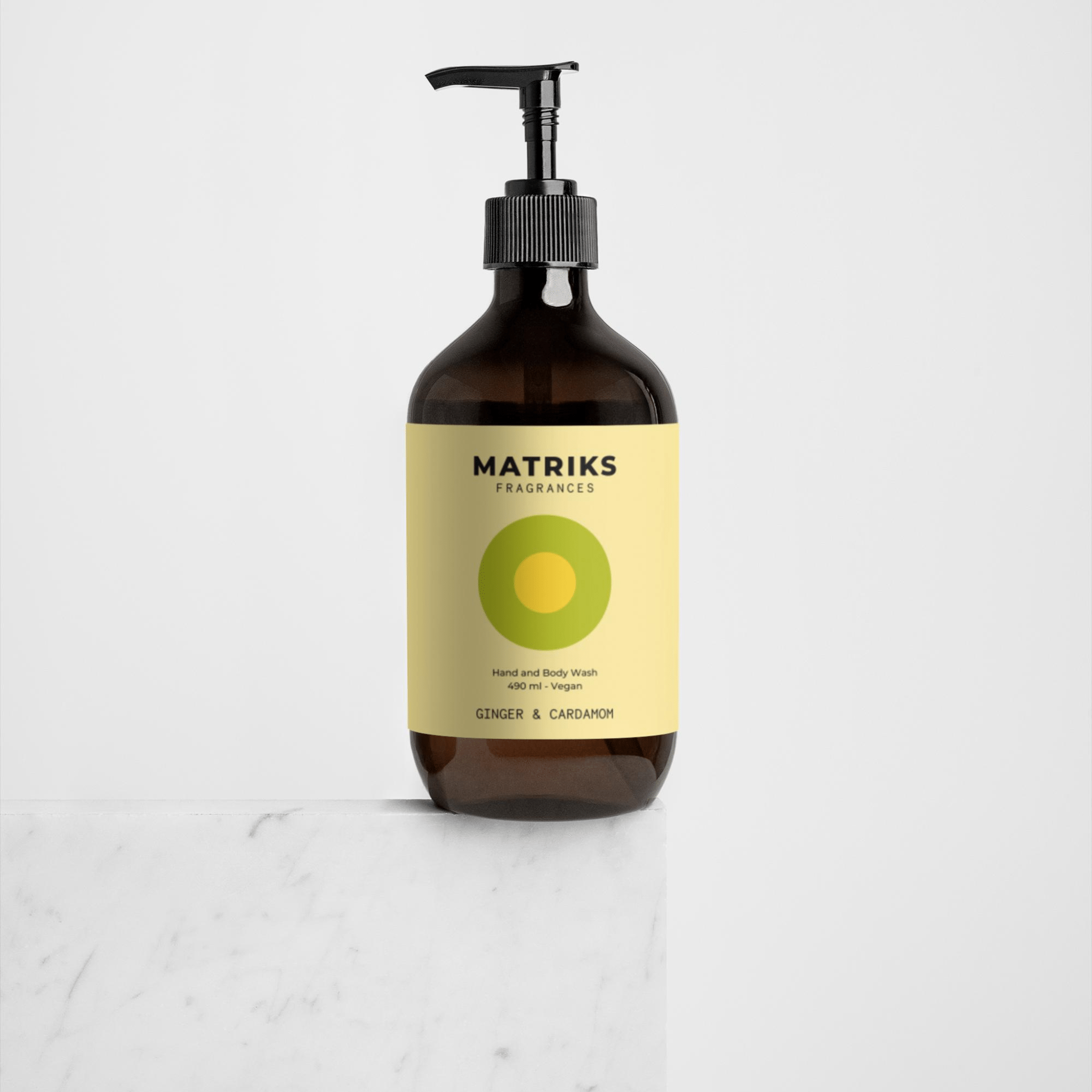 Een bruine pompflacon van Matriks Fragrances Hand & Body Wash Ginger & Cardamom 490 ml rust op wit marmer. Deze vegan body wash van Matriks Fragrances heeft unieke geuren tegen een lichte achtergrond.