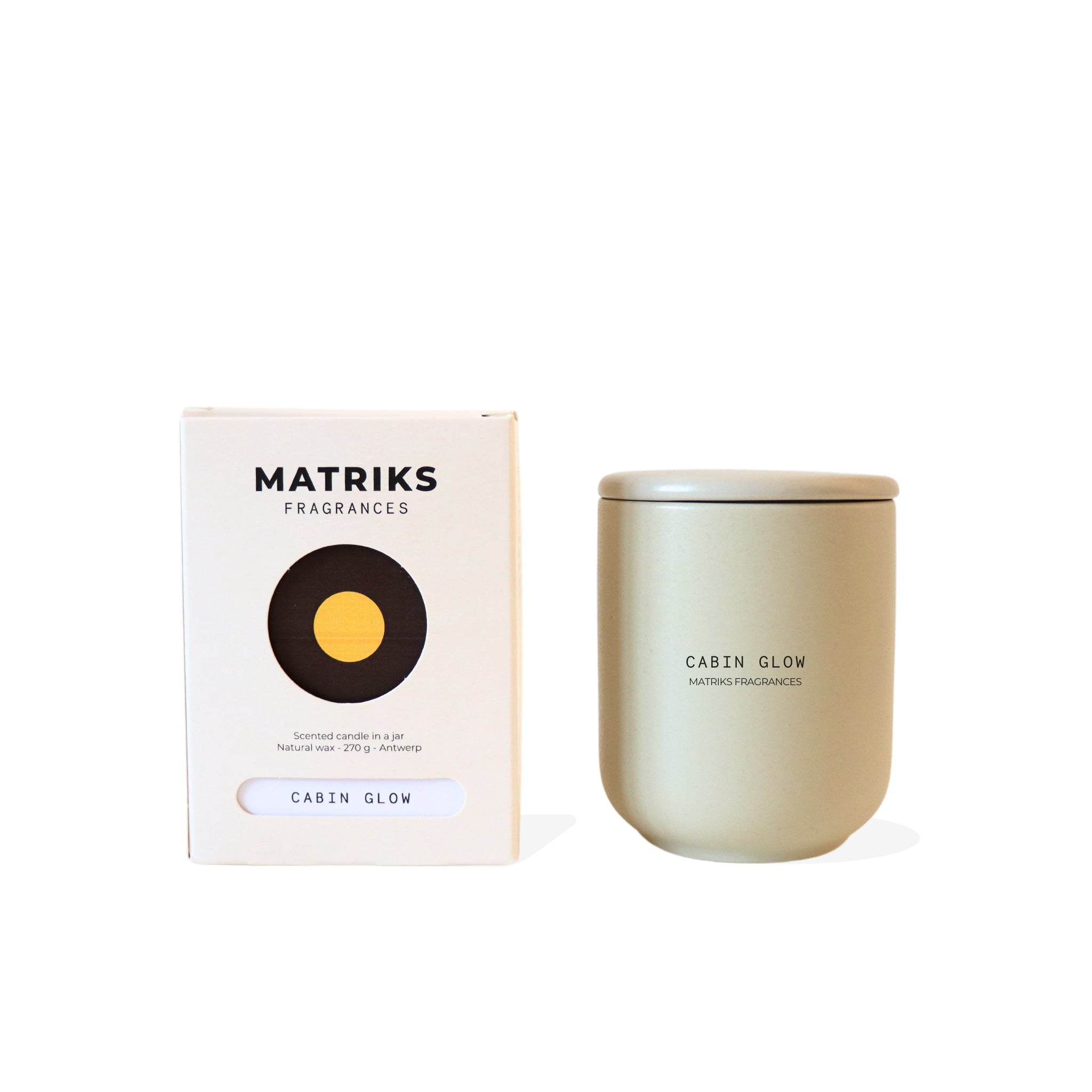 Een beige Matriks Fragrances Geurkaars Keramiek Cabin Glow 270g zit naast een witte doos met het logo van het merk en een gele cirkel - handgemaakt in Antwerpen voor de perfecte gezellige sfeer.