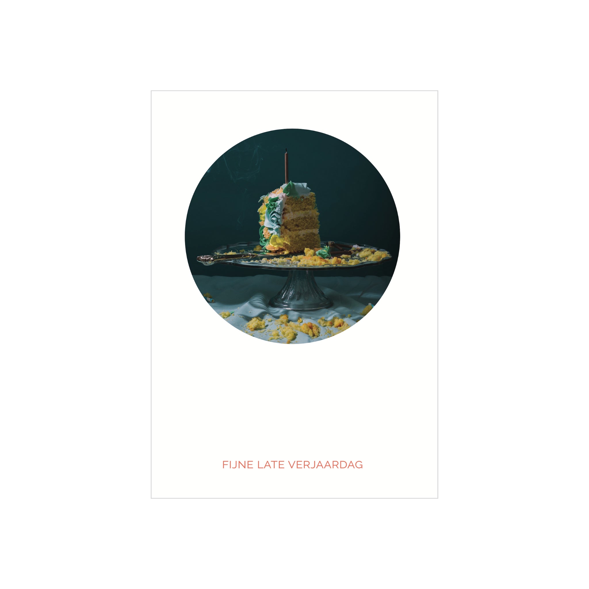 Een half opgegeten laagjescake met een kaarsje staat op een standaard te midden van kruimels; eronder staat de Matriks Postkaart Cirkel Fijne Late Verjaardag Dubbel A6 kaart van Matriks met de tekst "FIJNE LATE VERJAARDAG" in rood, tegen een donkere achtergrond.