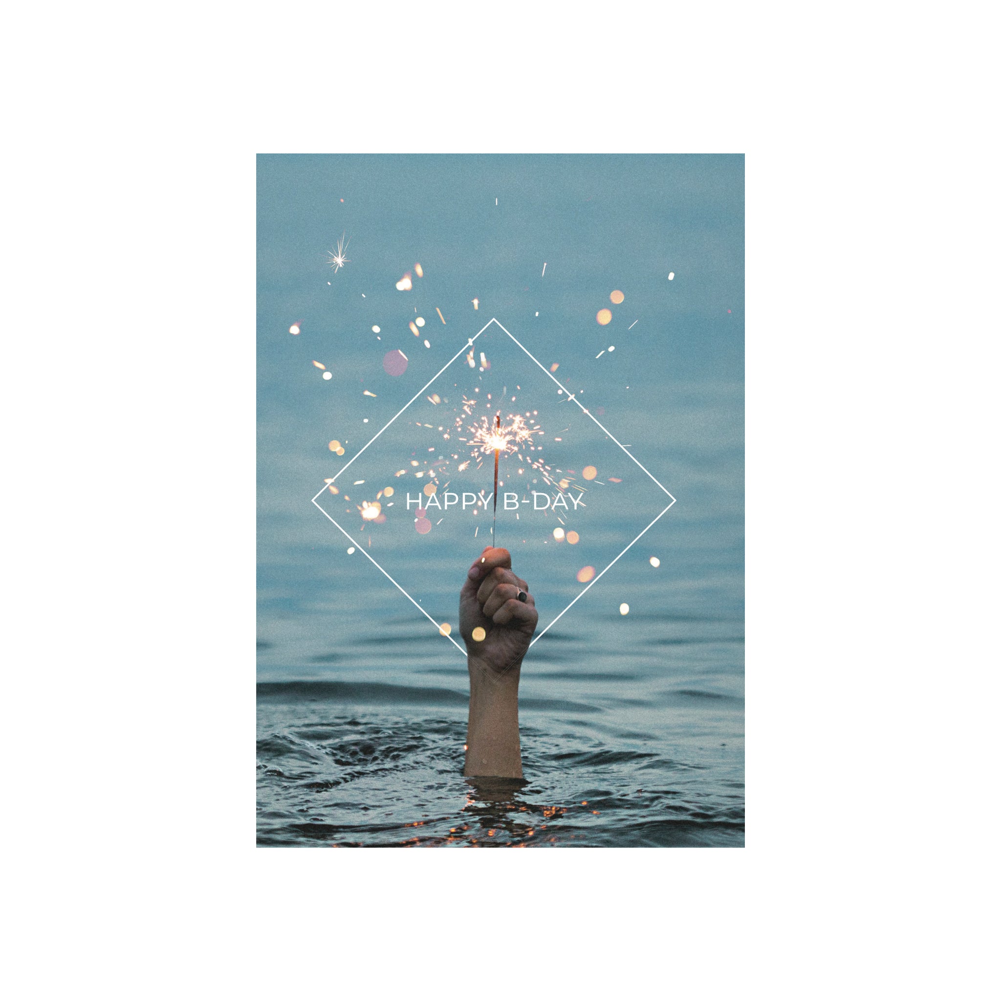 Een hand met een aangestoken fonkelaar stijgt op uit blauw water, de vonken vliegen ervan af, onder "HAPPY B-DAY" in een witte ruit-Matriks Postkaart Lijn Happy B-Day Dubbel A6 van Matriks. Ideaal voor wenskaarten, om elke verjaardag extra speciaal te maken.
