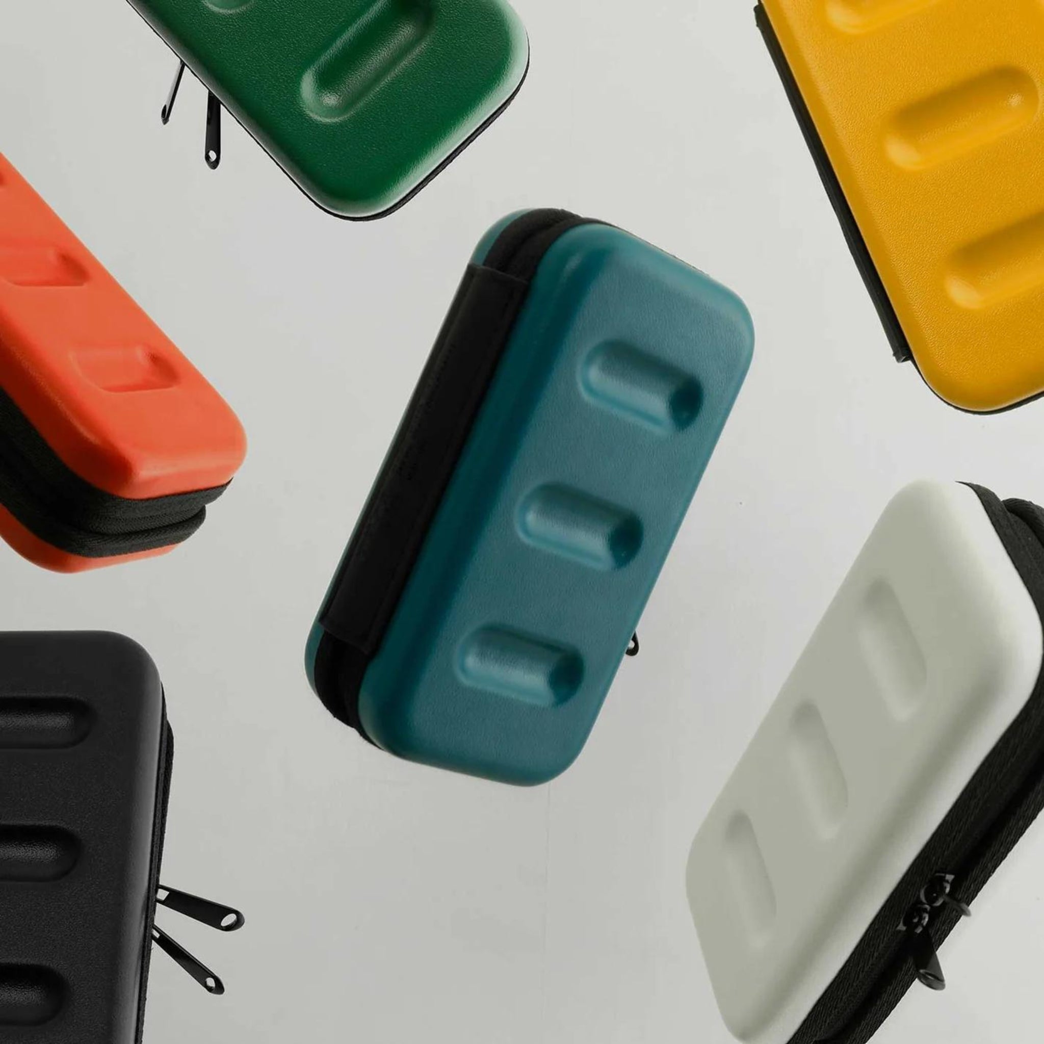 Verschillende Nähe Hard Shell Organizer Ivoor S etuis van Nähe worden getoond op een lichte achtergrond - sommige plat, andere schuin - in ivoor en perfect als compacte hard shell organizers voor het opbergen van gadgets.