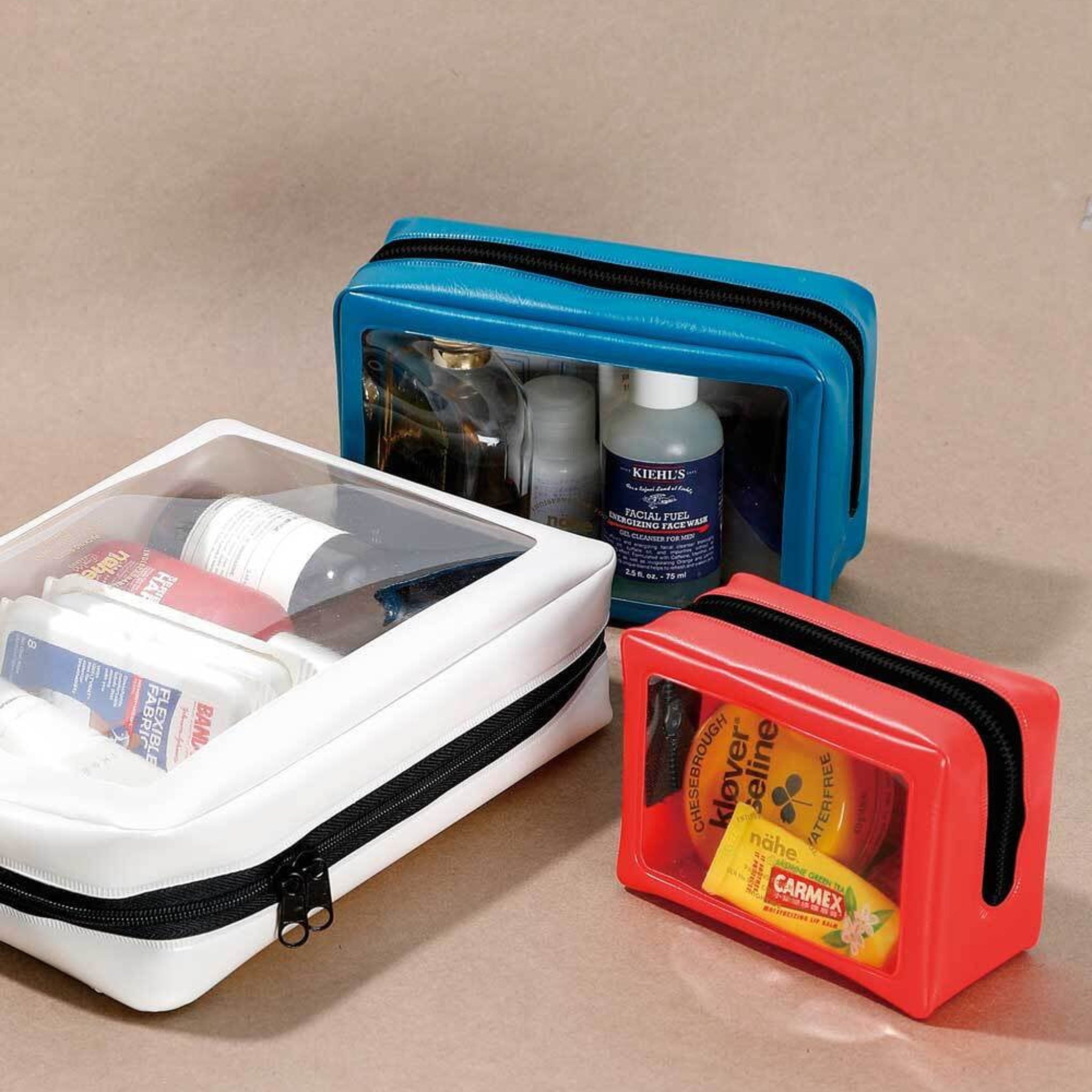 Het Nähe Reiszakje Zwart S van Nähe is een zwarte toilettas met rits en een doorzichtig voorpaneel, perfect voor het netjes opbergen van verzorgingsproducten zoals flesjes, potjes en lippenbalsem. Het wordt weergegeven op een neutraal oppervlak.