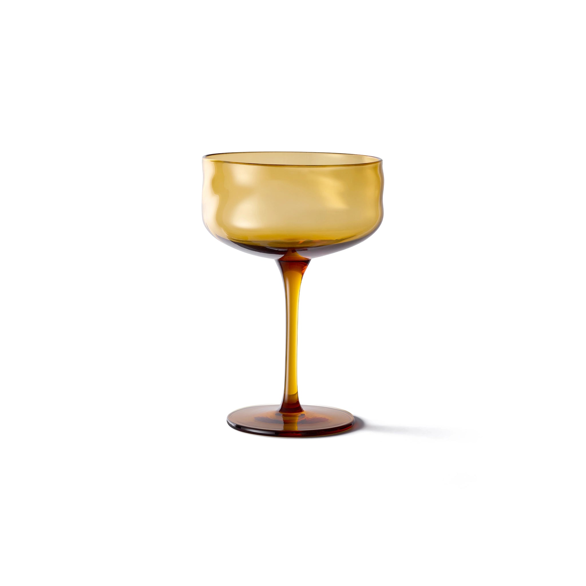 De Paveau Swirl Champagne Coupe Dune Geel 26 cl van Paveau is een amberkleurig borosilicaatglas met een brede kom, slanke steel en ronde voet, weergegeven op een effen witte achtergrond.