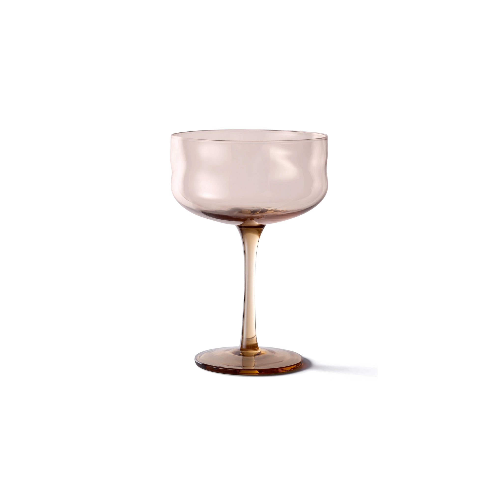 De Paveau Swirl Champagne Coupe Glow Beige 26 cl van Paveau heeft een doorschijnende, lichtbruine brede schaal en slanke steel, die een subtiele gloed uitstraalt tegen een effen witte achtergrond.