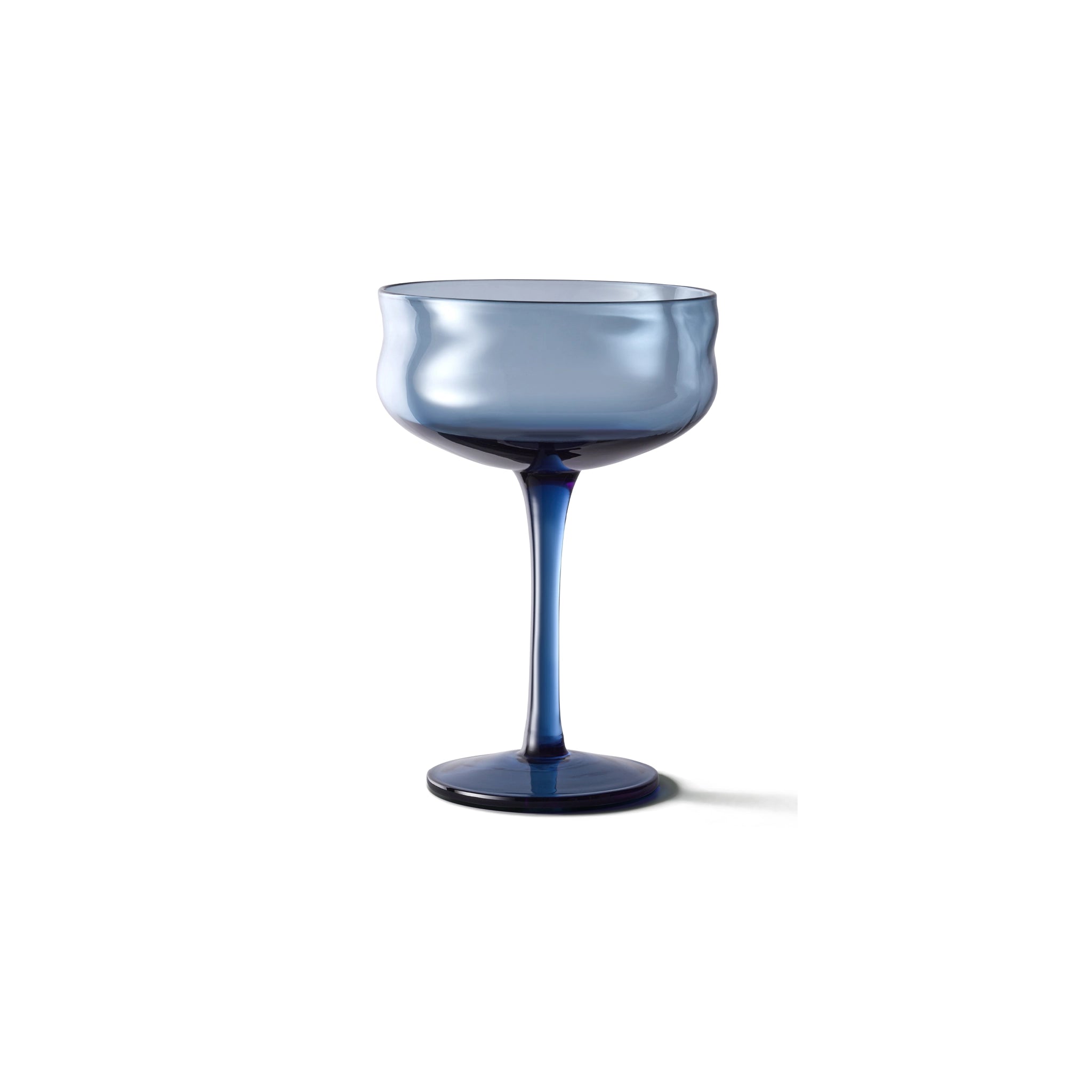 De Paveau Swirl Champagne Coupe Midnight Blauw 26 cl van Paveau heeft een blauwe tint met een brede kom en slanke steel, gemaakt van borosilicaatglas, tegen een effen witte achtergrond.