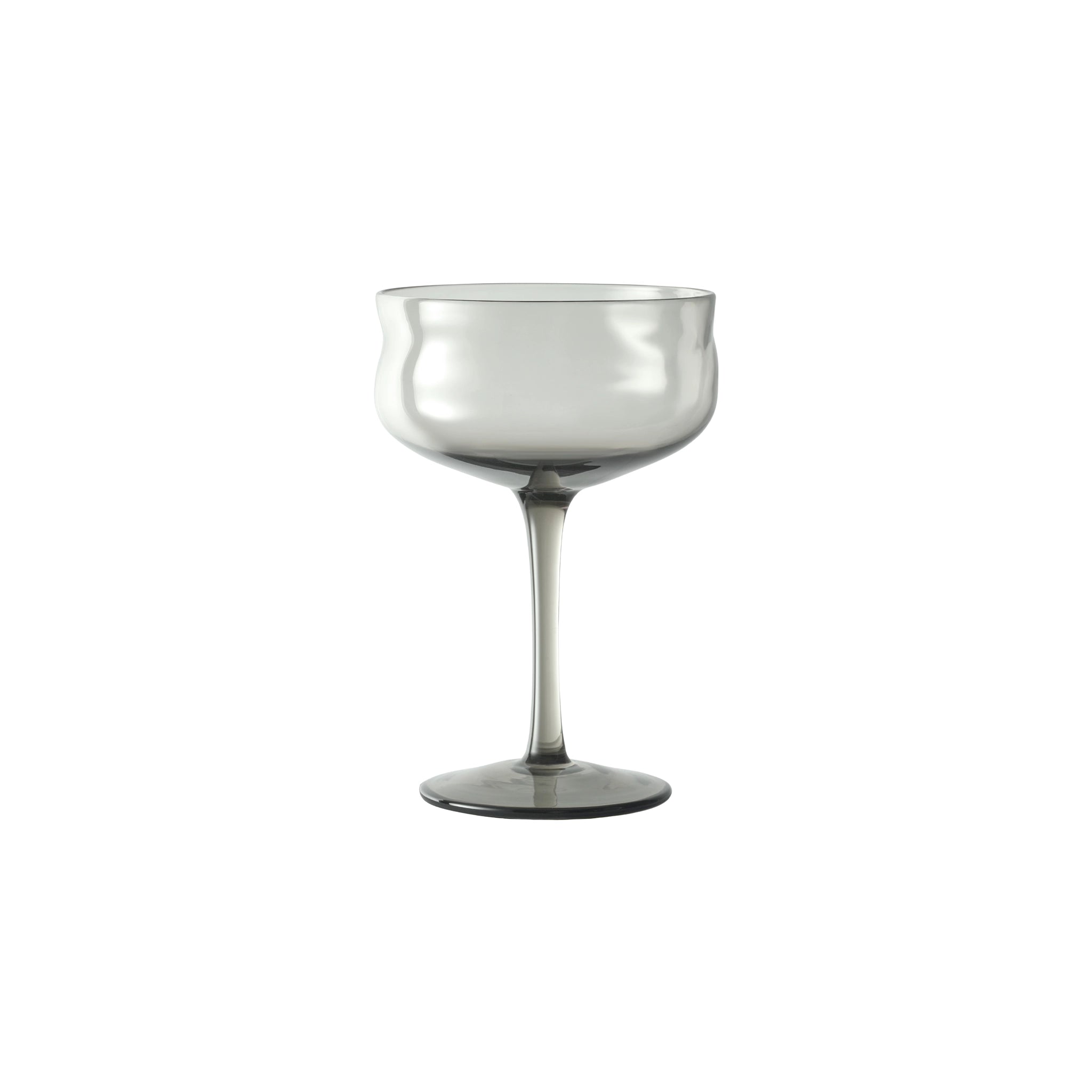 De Paveau Swirl Champagne Coupe Mist Smoke 26 cl van Paveau heeft een enkel transparant grijs glas met een brede, gebogen kom en lange steel, elegant weergegeven op een witte achtergrond.