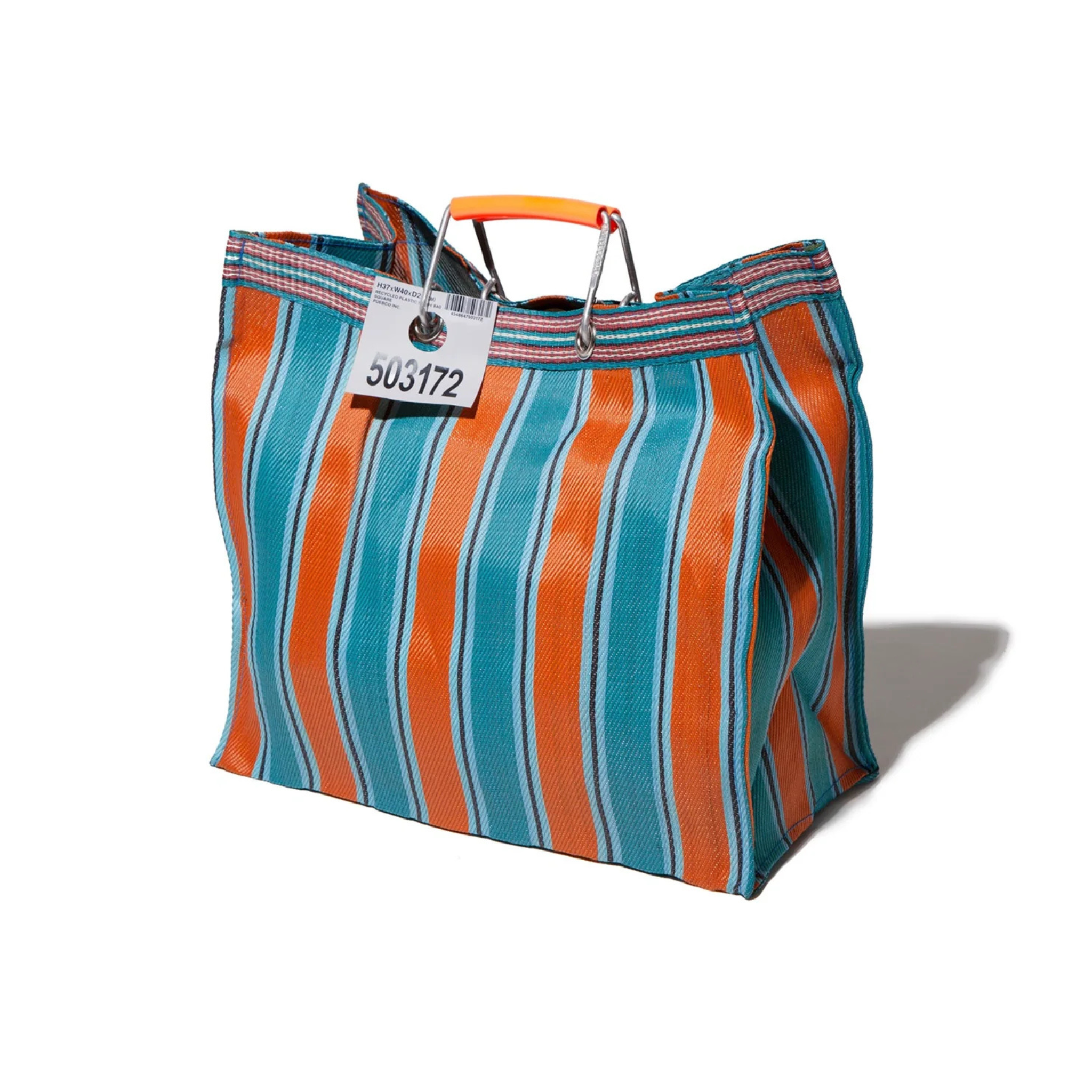 De Puebco Gerecycleerde Tas Strepen Oranje Blauw Vierkant is een grote tas met blauwe, oranje en witte verticale strepen, oranje plastic handvatten en een bagagelabel (5053172), gemaakt van gerecycled plastic door Puebco.