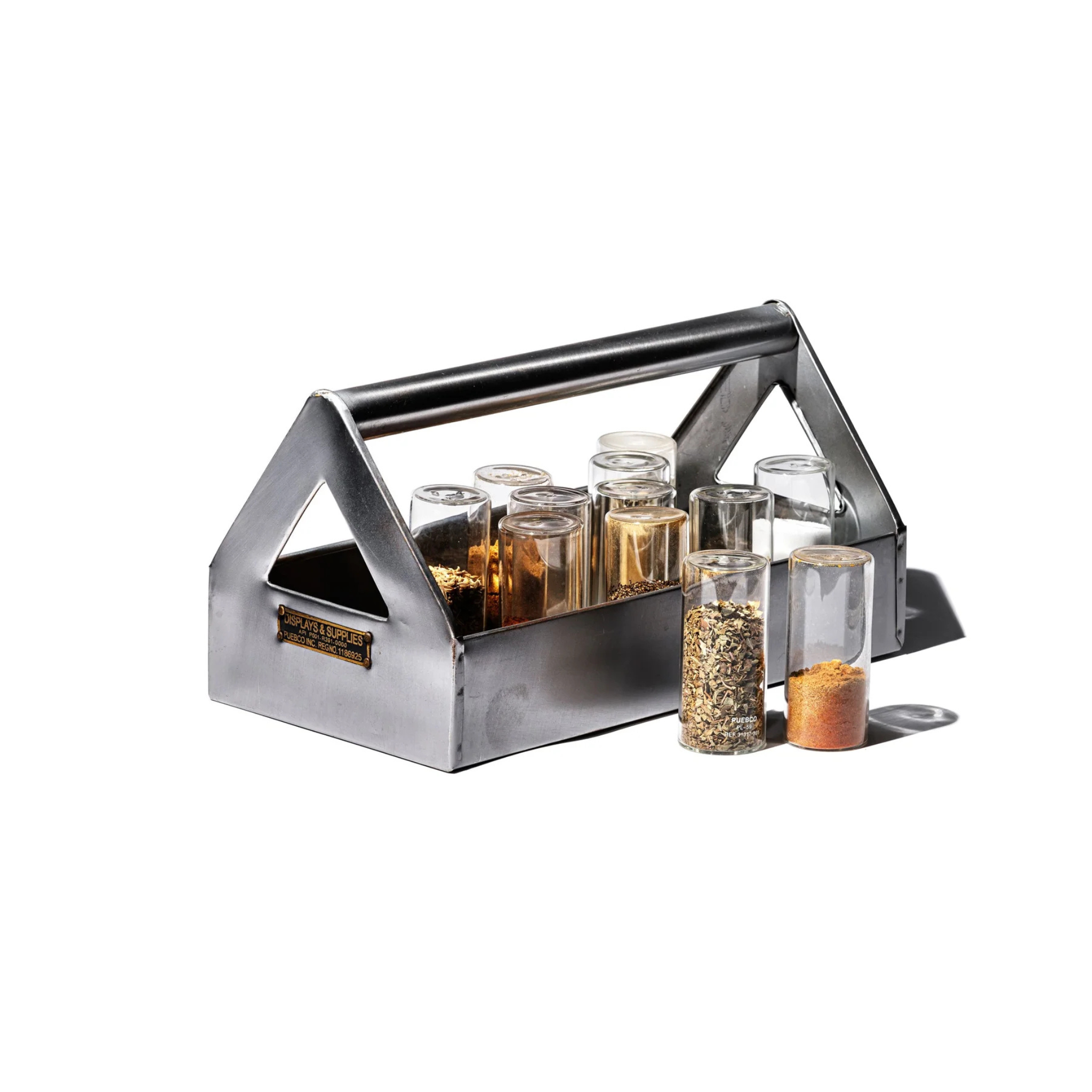 De Puebco Tool Organizer van Puebco toont acht kleine doorzichtige kruidenpotjes, sommige gevuld met specerijen; twee potjes staan naast de caddy. Het helder verlichte tafereel speelt zich af tegen een witte achtergrond.